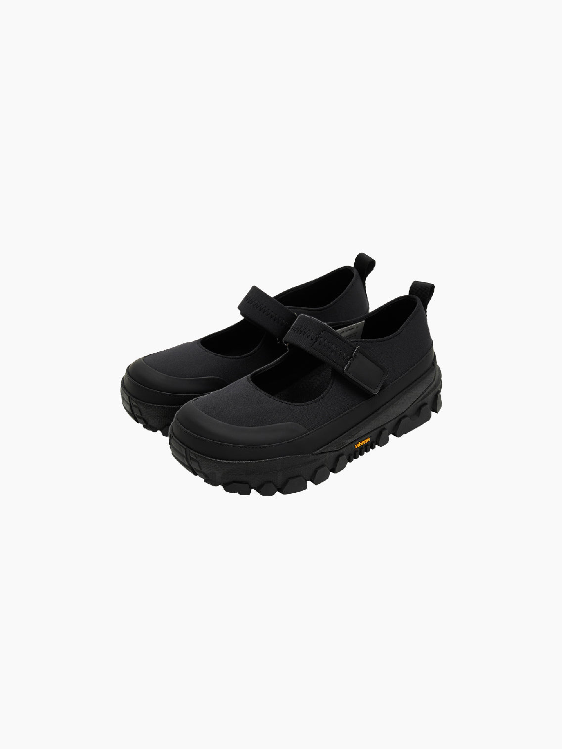 The Amomento Mary Jane Shoes Black feature a thick, rugged sole and a Velcro closing strap over the top. These shoes also include a pull-tab at the heel and have a logo on the side of the soft sole.