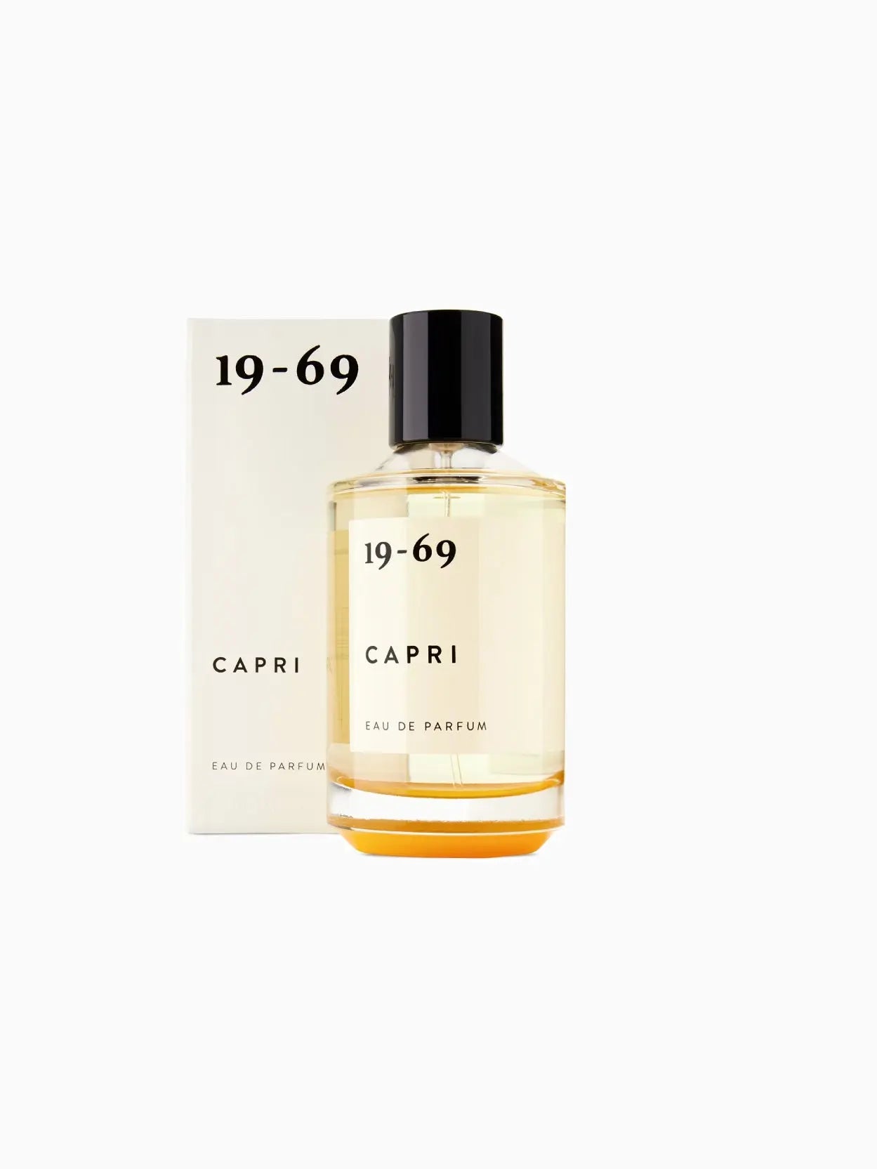 A clear glass bottle of Capri 100ml by 19-69 with a black cap, available at Bassalstore. The fragrance name "Capri 100ml" and "19-69" text is printed on the front in black, showcasing a yellow-tinted liquid inside.
