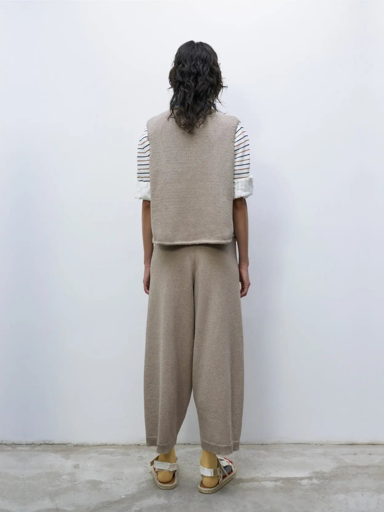 A pair of loose-fitting, knee-length, brownish-tan pants with an elastic waistband and ribbed cuffs at the hem is displayed on a plain white background. The material appears soft and slightly textured. Available as Cotton Knitted Pants Taupe by Cordera at Bassalstore in Barcelona.