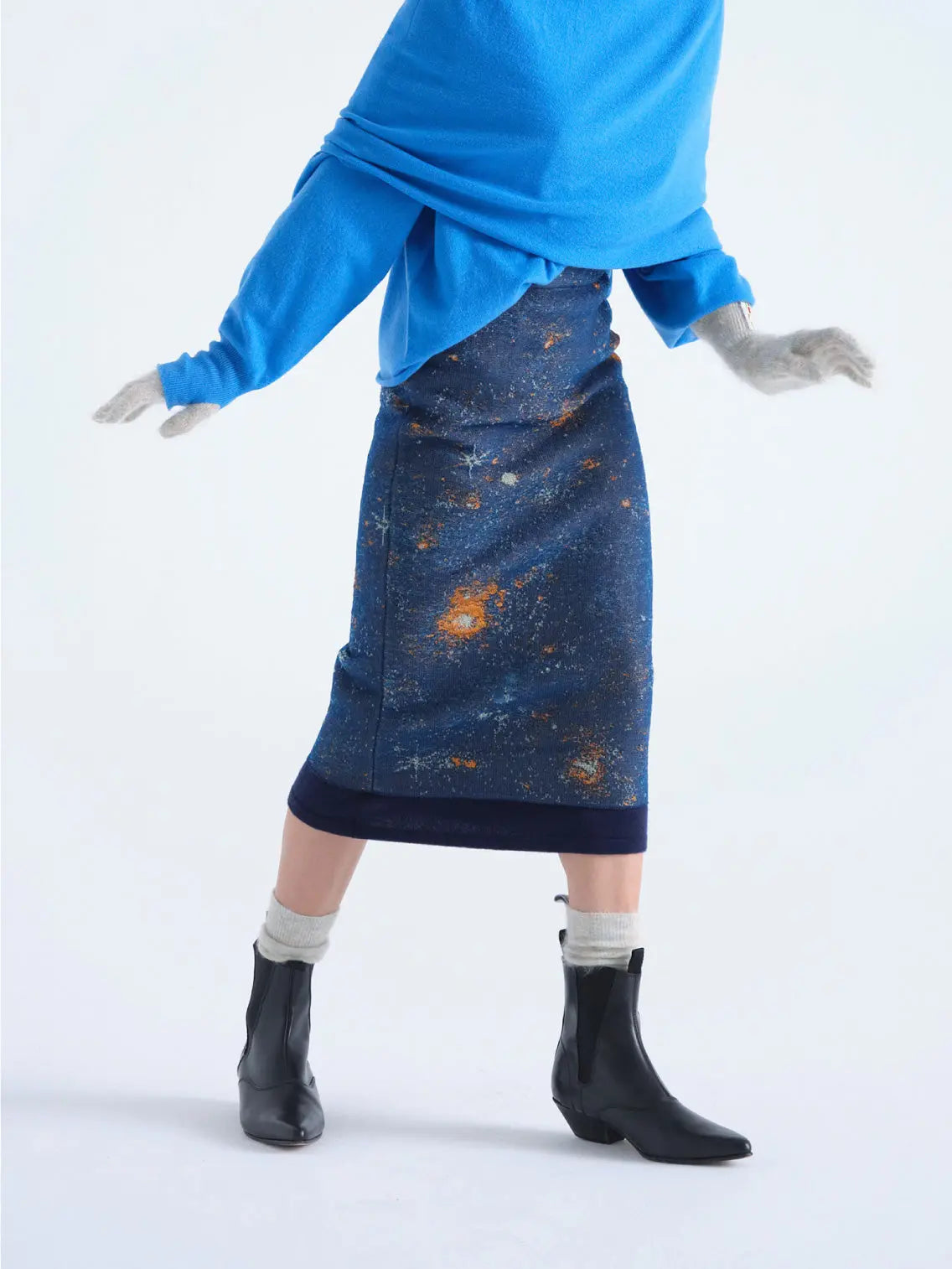 A Bielo Galaxy Skirt Navy, featuring a galaxy-inspired design with blues, oranges, and whites representing stars and cosmic dust on a dark blue background – available exclusively at Bassalstore in Barcelona.