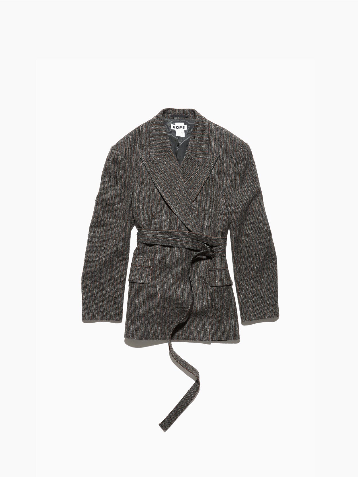 The Strava Blazer Grey Herringbone by Hope is crafted from textured vintage wool in a grey herringbone pattern, featuring a wrap-around belted waist. The blazer includes two front pockets and a notched lapel collar, with an inner label displaying "DEPT.