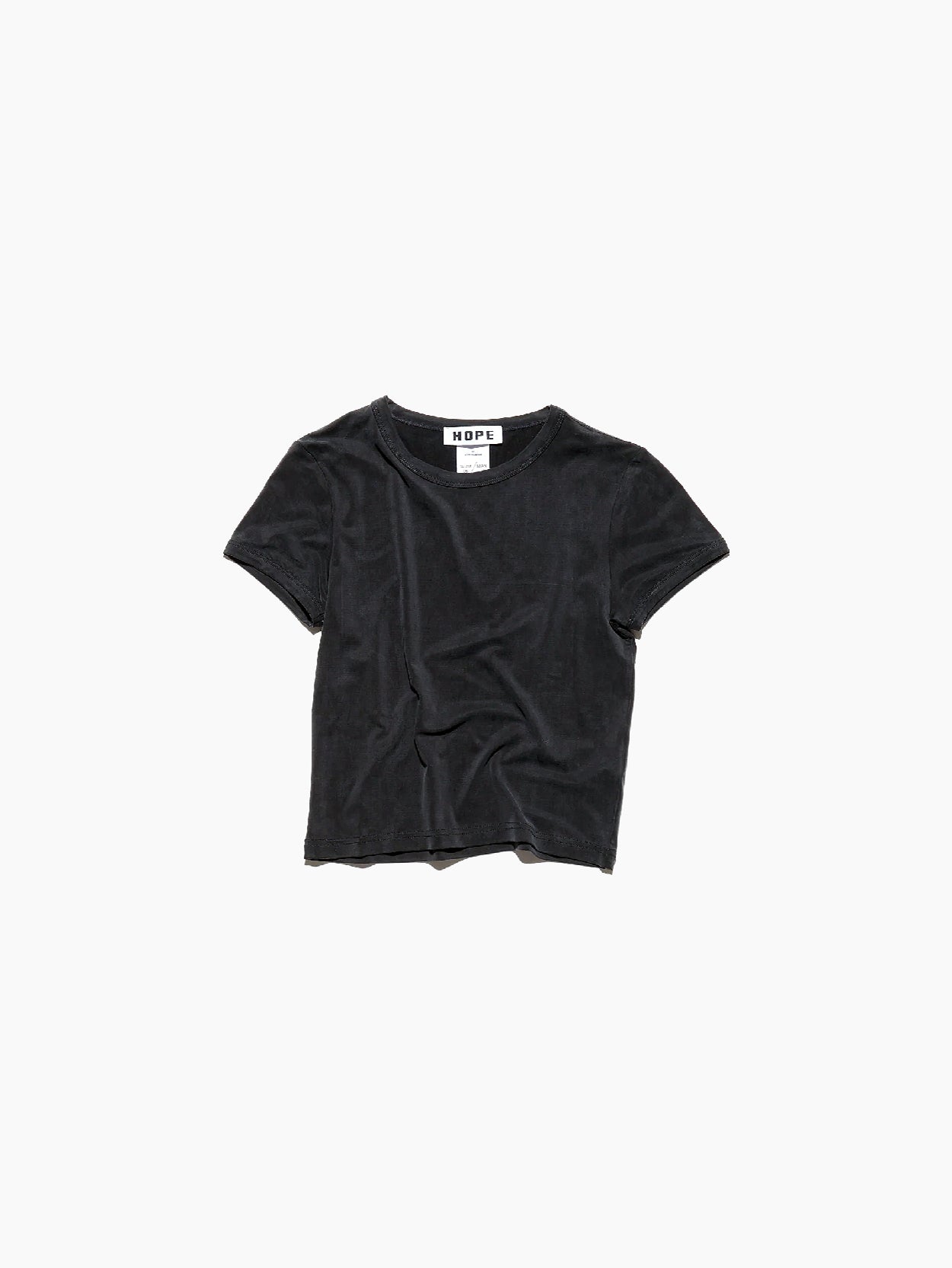 A short-sleeve, black velvet Vile T-Shirt Black, with a slight wrinkling on the front, laid flat on a white background. The collar label reads "Hope." This t-shirt boasts a washed silky look, adding an extra touch of elegance.