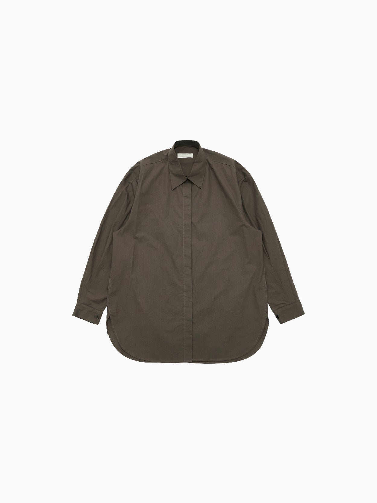 A long-sleeved, dark brown button-up shirt displayed on a white background. Crafted from high-density cotton, the Amomento Oversized Shirt features a classic pointed collar and a relaxed, minimal oversized fit with a curved hemline at the bottom.