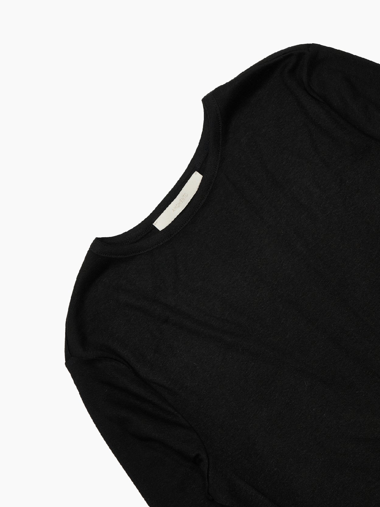 A plain, long-sleeved Round T-Shirt Black from Amomento is displayed against a white background. Crafted from wool tencel, the shirt features a round neckline and a simple, fitted design without any visible logos or patterns. This versatile top effortlessly combines comfort and style.