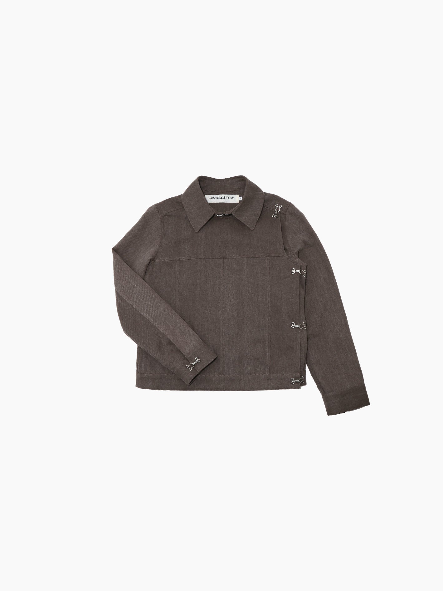 Aurembiaix's Canvas Jacket is a minimalist gray, long-sleeved canvas jacket with a pointed collar and hook and eye fastening closures on the right side. Made from 100% cotton, it boasts a straight hem and no visible pockets, displayed against a plain white background.