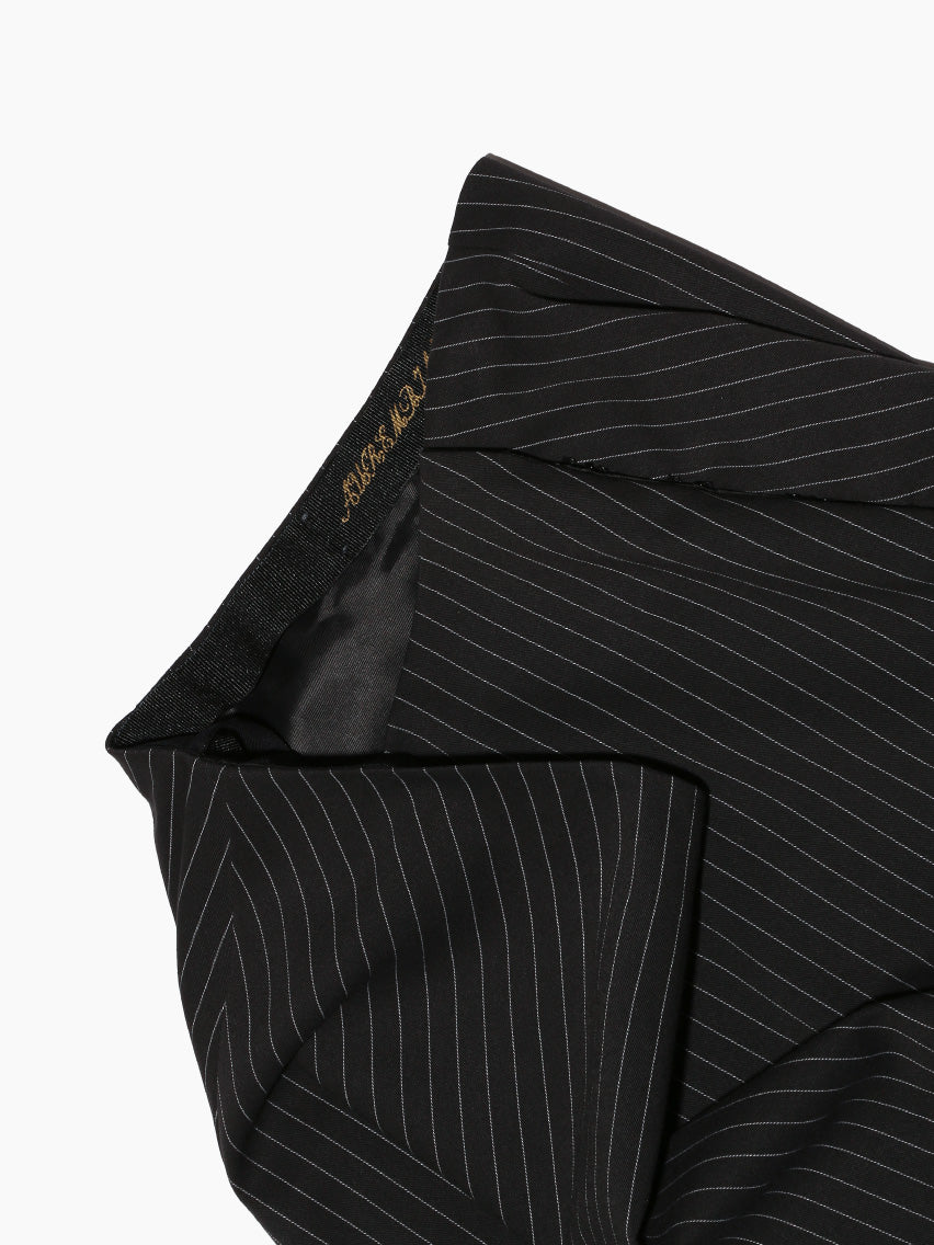 Aurembiaix's Pinstripe Walking Skirt, made in Spain, is a black cotton knee-length skirt with subtle vertical pinstripes and a hook and eye closure, displayed flat against a white background.