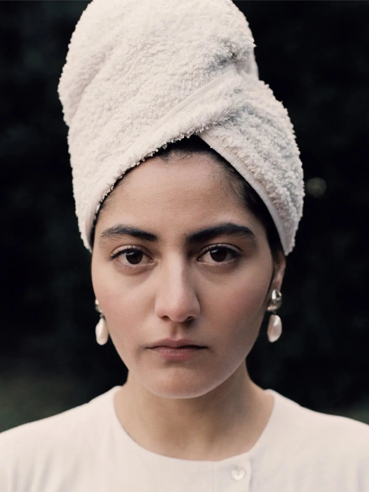 A pair of elegant Ava Earrings with small, silver spherical studs and irregular, baroque freshwater pearls dangling from each, available exclusively at Nathalie Schreckenberg Bassalstore, set against a plain white background.