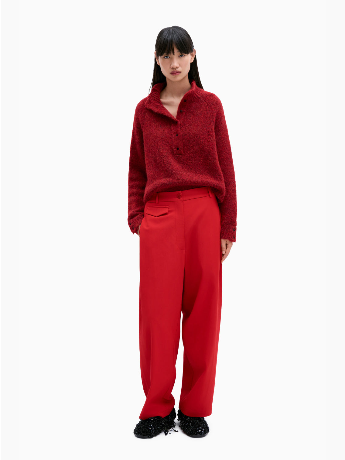 The Baby Alpaca Polo Sweater Dhalia by Cordera is a red, long-sleeve knit sweater with a round neck and a button-up front. This timeless piece features ribbed cuffs and hem, adding a cozy texture to the garment.