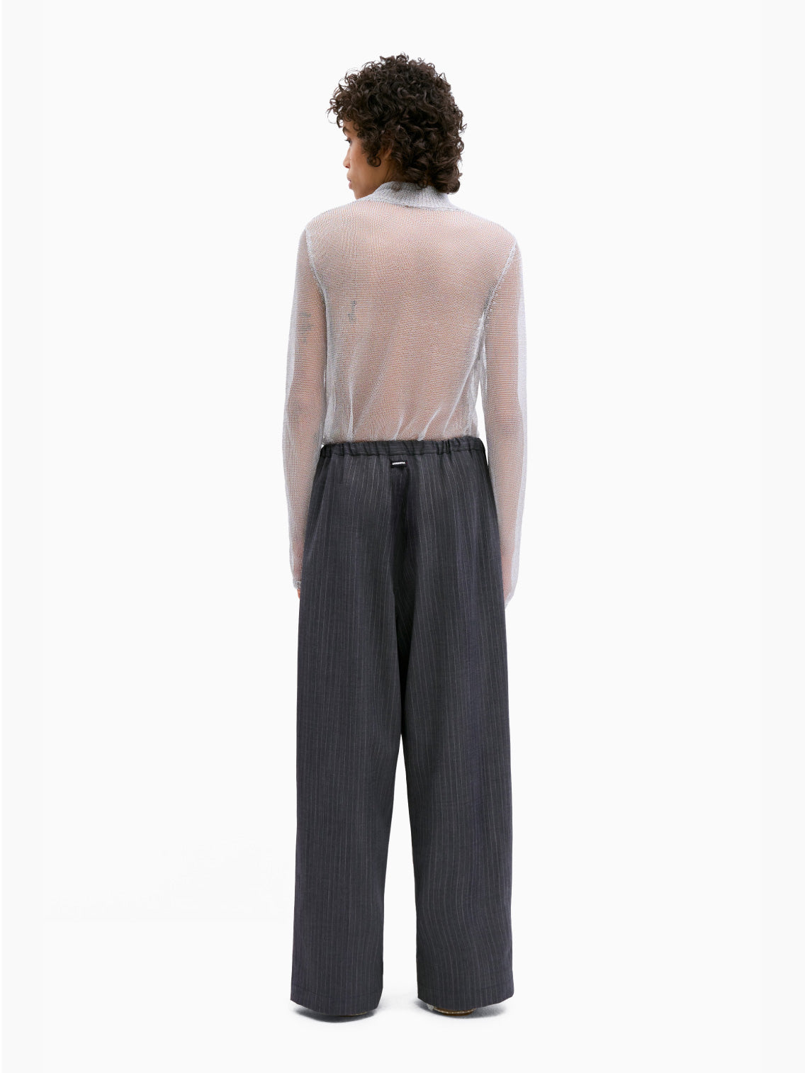 Introducing the Classic Striped Pants Grey by Cordera: a pair of grey wide-leg pants with a subtle pinstripe pattern. These pants feature a drawstring waistband and convenient side pockets, ensuring a comfortable and adjustable fit. The lightweight fabric and casual design make them perfect for relaxed or everyday wear.