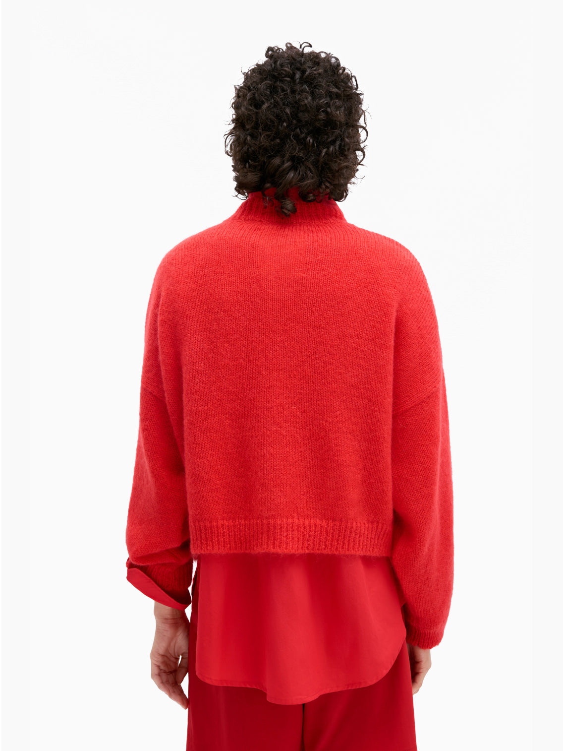 A vibrant red Mohair Sweater from Cordera, featuring long sleeves and a round neckline. This transitional knitwear showcases a ribbed collar, cuffs, and hem with a slightly loose and boxy fit. The fabric appears soft and cozy, crafted from mohair merino wool, making it perfect for cooler weather.