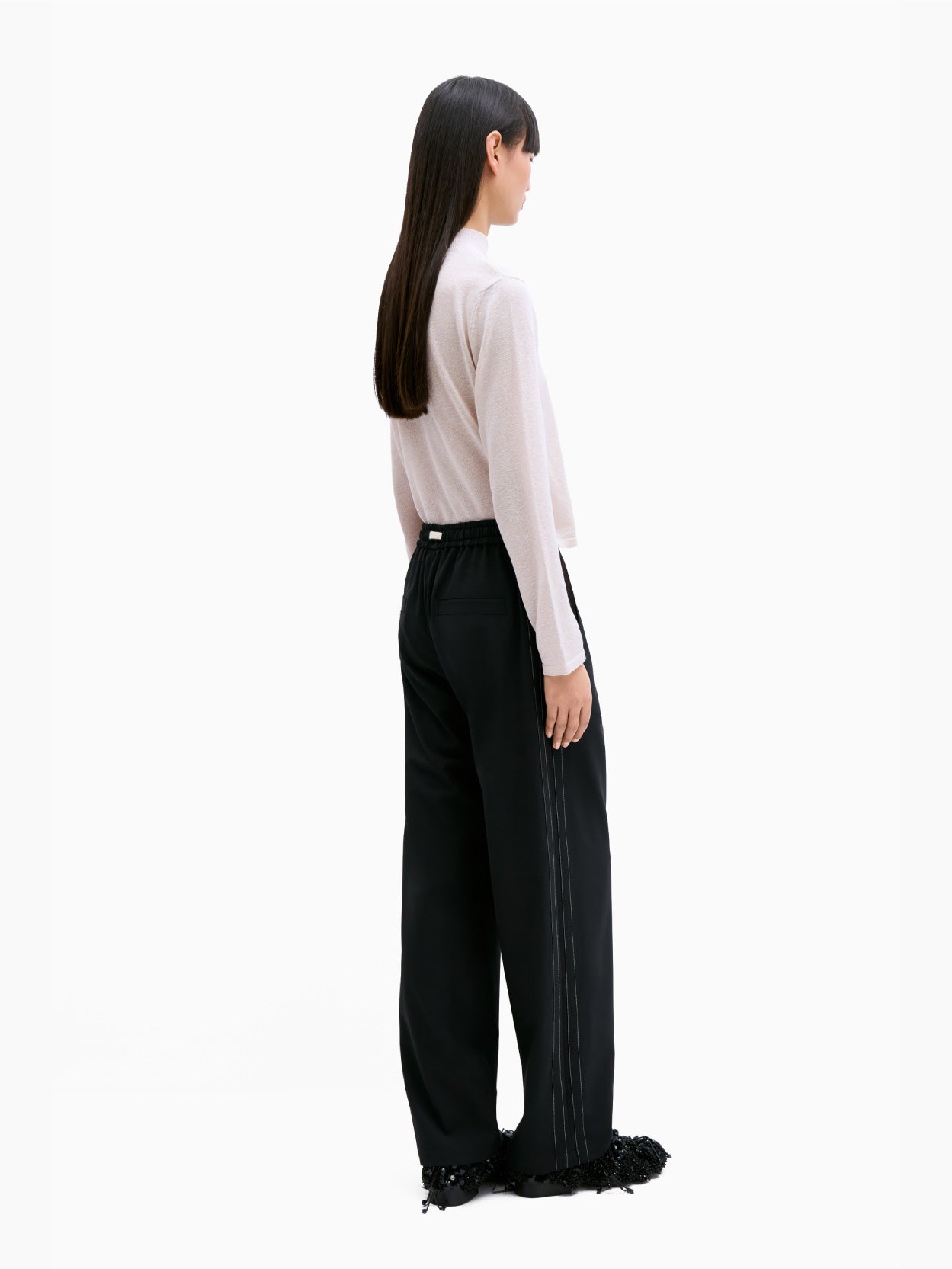 Cordera's Tailoring Drawstring Pants in Black feature an elasticated waistband with a white drawstring. These wide-leg pants have subtle white stitching along the sides and provide a relaxed fit. Their contemporary design is highlighted as they are laid flat against a white background.