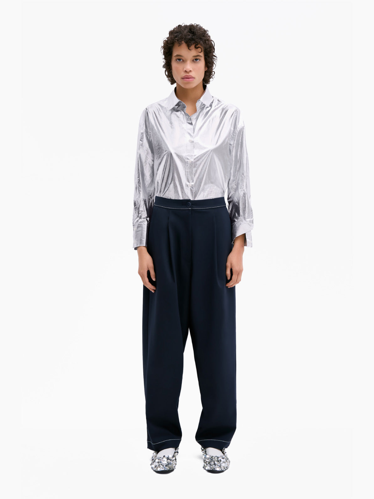 A pair of Tailoring Stitch Pants Navy by Cordera with a high waist and a button on the waistband. Featuring subtle pleats down the front and a slightly cropped length, these navy pants are a contemporary design that make for a perfect wardrobe staple.