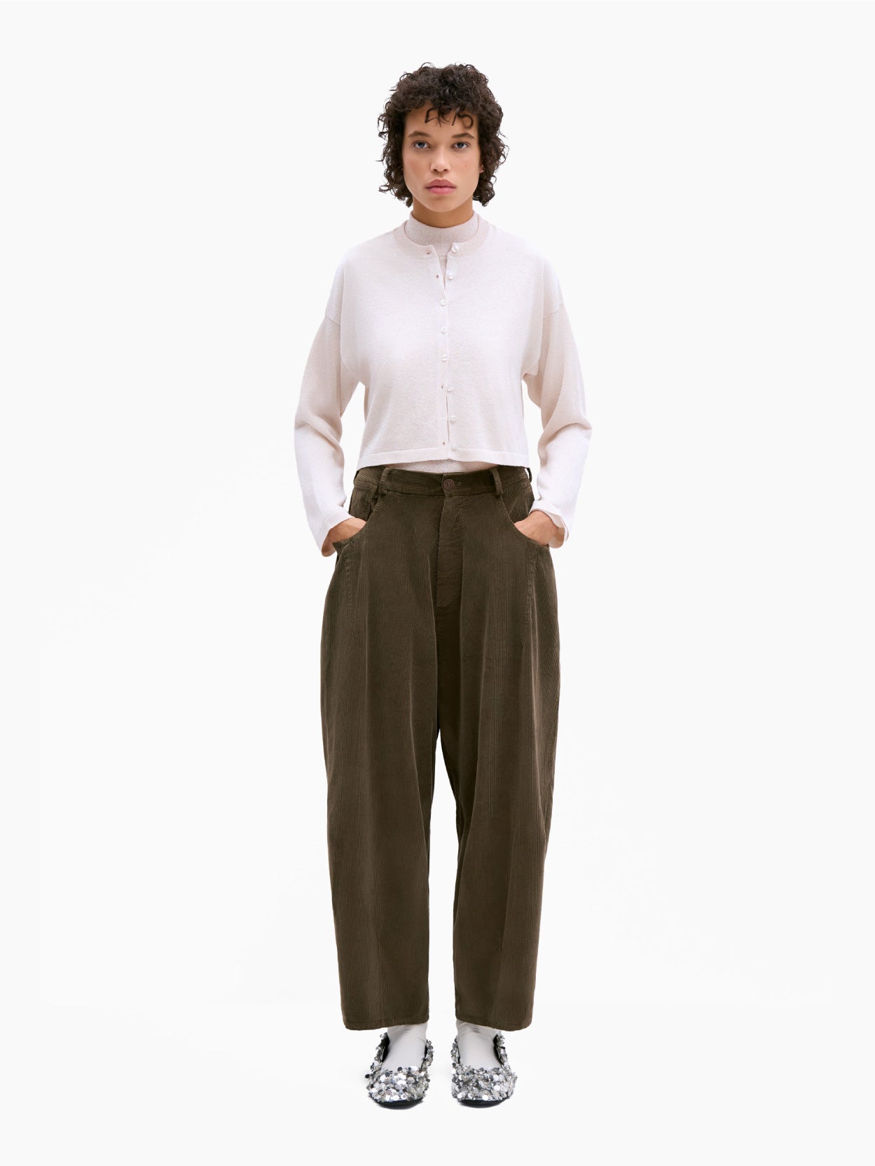 Cordera's Corduroy Baggy Pants Moss are stylishly designed with a high waist, wide legs, and a relaxed fit. These dark brown corduroy pants feature two side pockets, belt loops, and an elasticated waistband for added comfort. The pants are displayed laid flat against a white background.