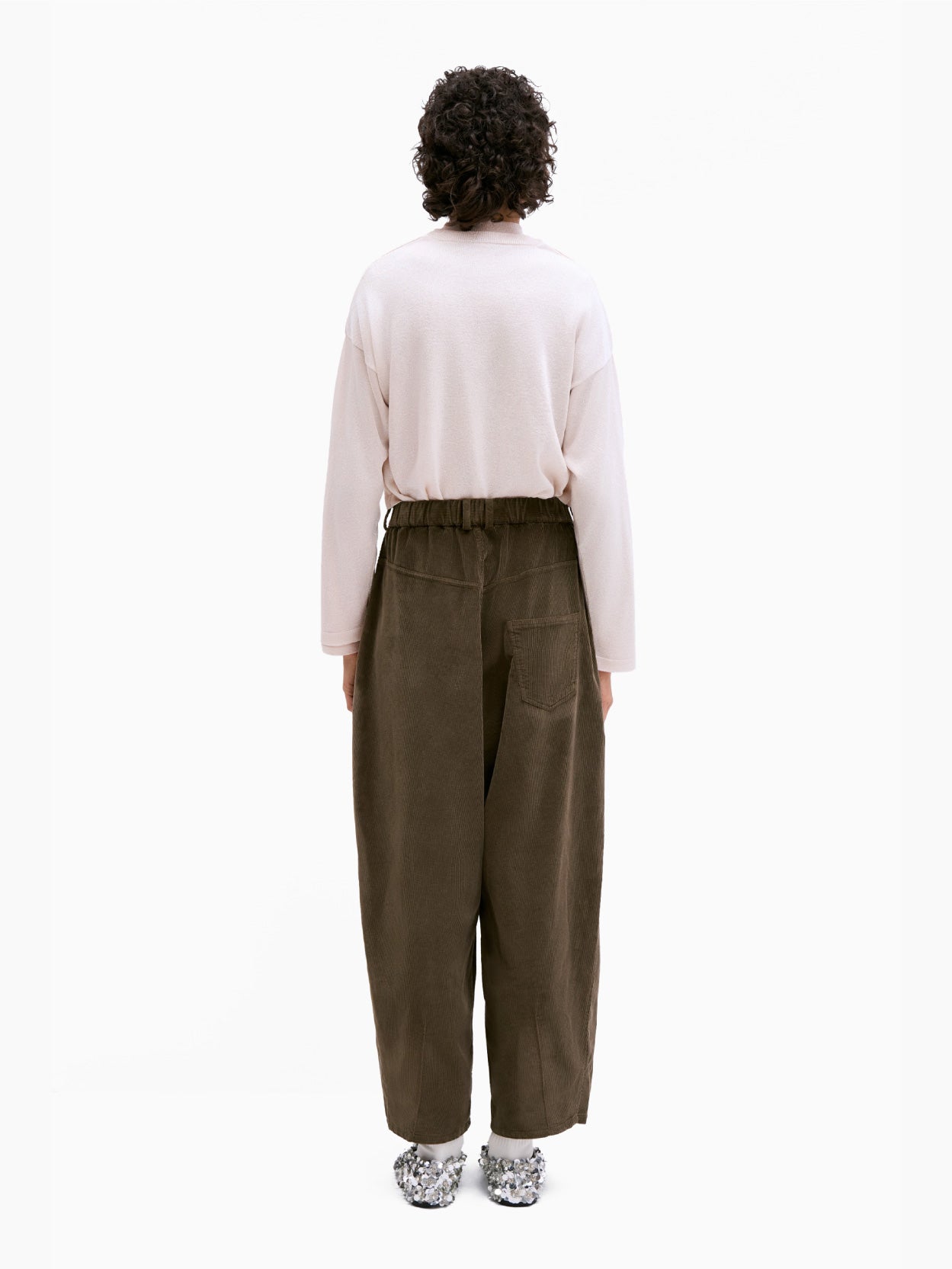 Cordera's Corduroy Baggy Pants Moss are stylishly designed with a high waist, wide legs, and a relaxed fit. These dark brown corduroy pants feature two side pockets, belt loops, and an elasticated waistband for added comfort. The pants are displayed laid flat against a white background.