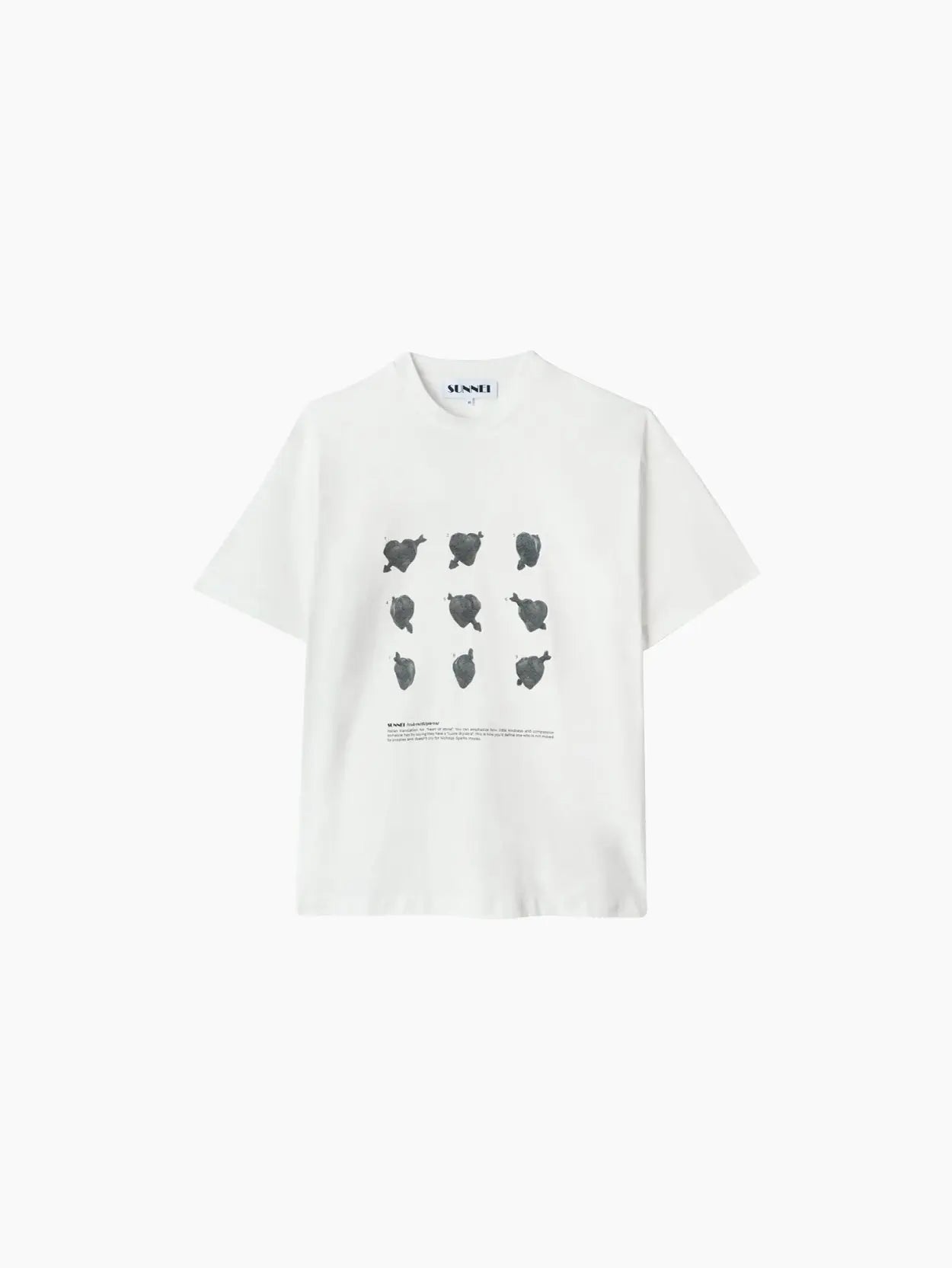 A white short-sleeved Classic T-Shirt "Cuori di Pietra" by Sunnei with a minimalist design featuring nine black abstract shapes arranged in a grid pattern on the front. There is text below the shapes. Available exclusively at Bassalstore, your go-to store in Barcelona.
