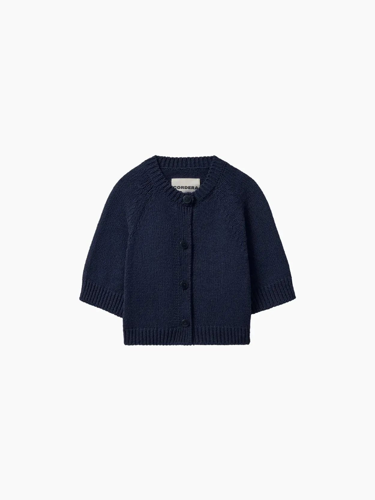A navy blue, long-sleeve, knitted cardigan for a baby available at Bassalstore. The **Cotton Buttoned Top Navy** from **Cordera** features a round neckline, ribbed cuffs and hem, and button closures down the front. The fabric appears soft and cozy, ideal for keeping a baby warm.