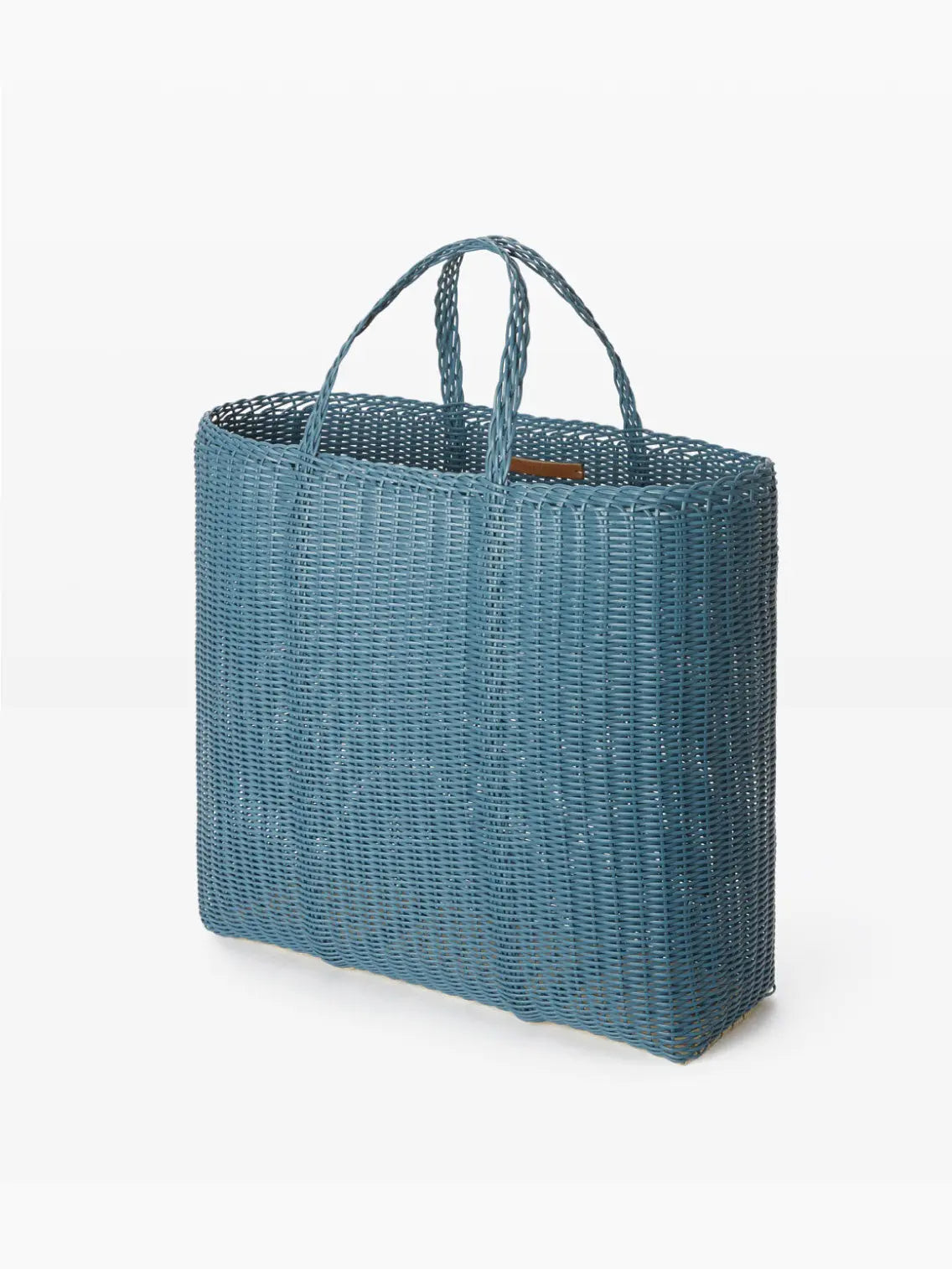 A rectangular, blue woven tote bag with dual handles. The Flat Large Paloblue Bag's woven texture is prominently displayed with vertical and horizontal patterns, giving it a stylish, handcrafted appearance. Available exclusively at Bassalstore in Barcelona, the plain white background emphasizes the bag's design features by Palorosa.