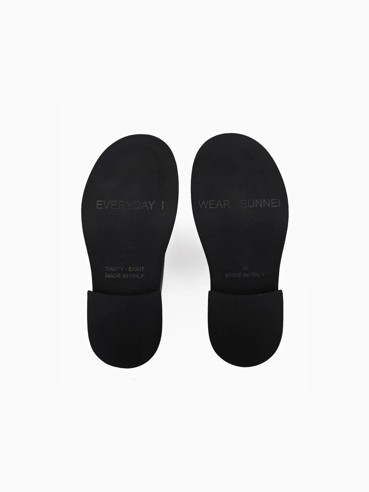Image of a single black Sunnei Form Marg Black shoe viewed from the side, available at Bassalstore in Barcelona. The shoe features a rounded toe, a thick strap across the top with a velcro closure, and a chunky sole. The background is plain white.
