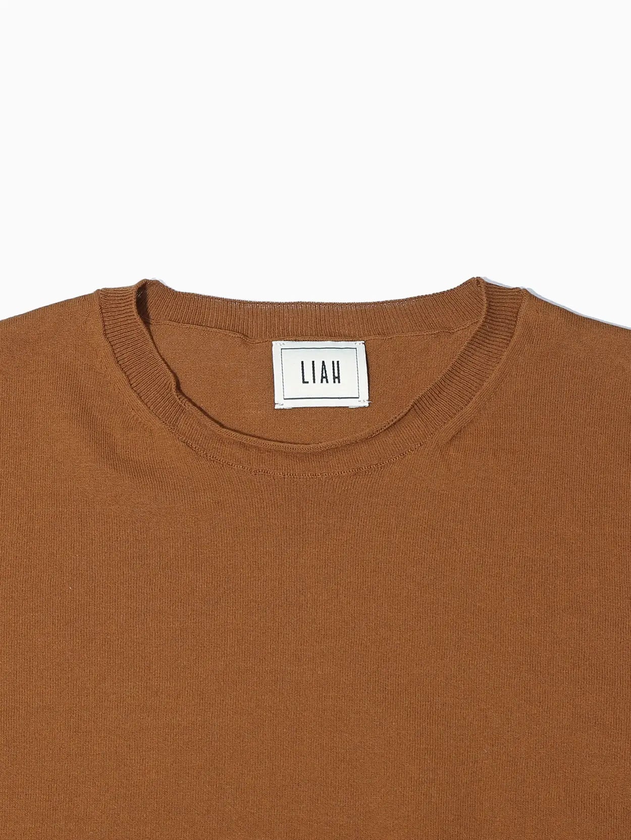 A Gia T-Shirt Caramel by Liah with a round neckline, displayed on a white background. The tag inside the collar appears to have text on it. The T-shirt, available at Bassalstore in Barcelona, looks simple and casual in design.