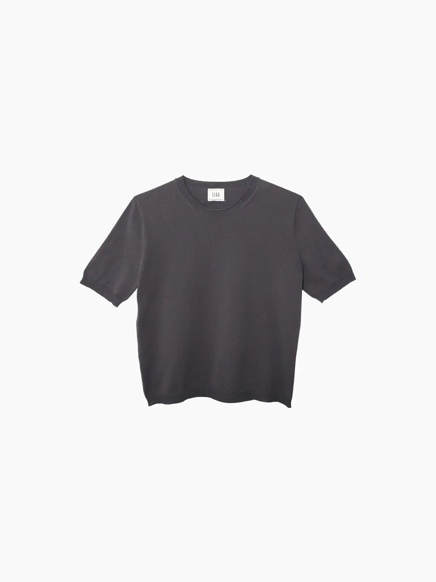 A plain, dark gray, short-sleeved T-shirt with a round neckline is displayed against a white background. This minimalistic design from Liah features no visible logos or graphics, offering a versatile addition to any wardrobe. This is the Gia T-Shirt Grey.