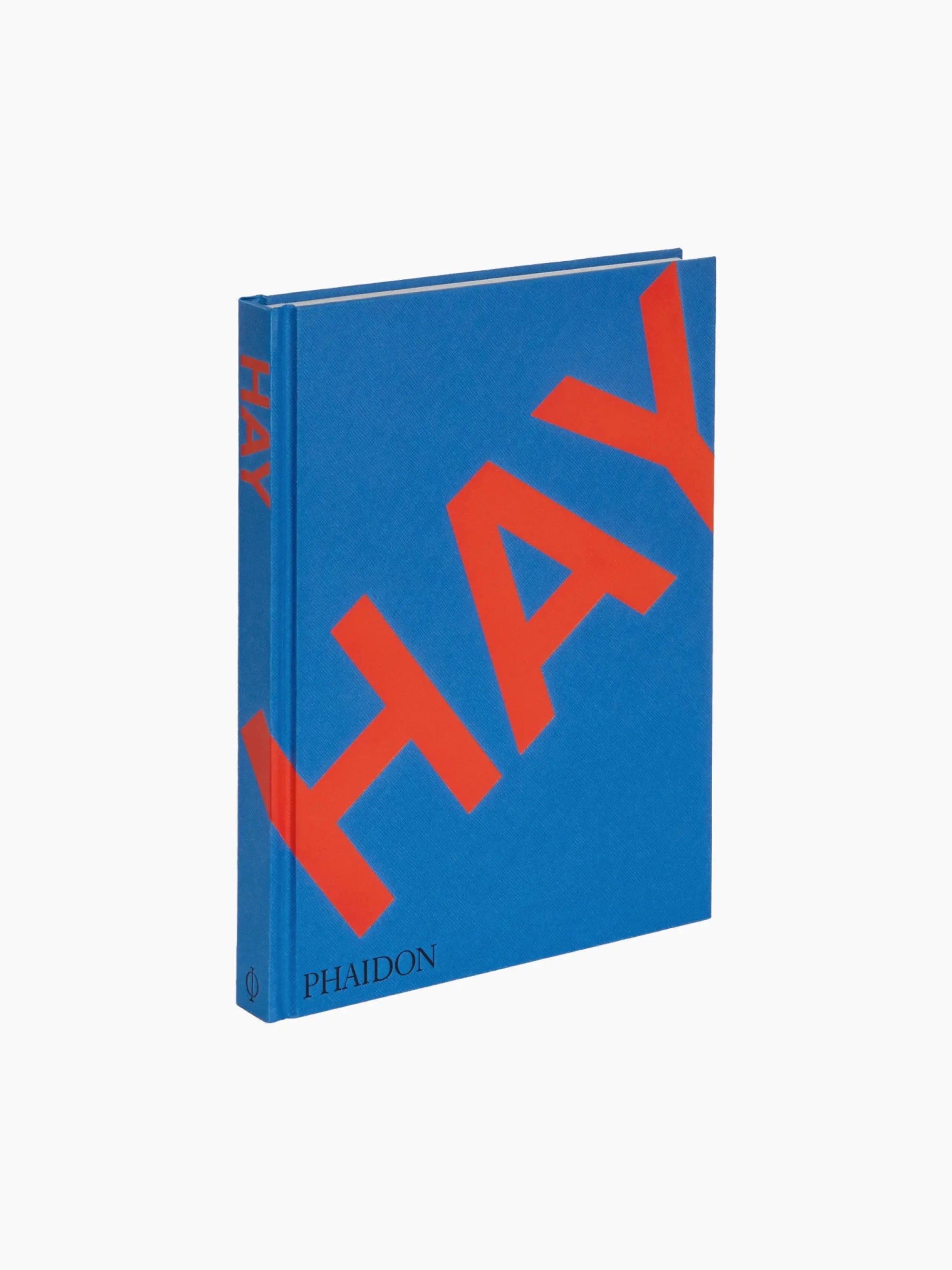 A blue hardcover book with the word "HAY" in large red letters diagonally across the front cover. The spine also features "HAY" in red text, while the bottom has "Phaidon" printed smaller. Perfect for any store, its plain white background makes it a standout piece.