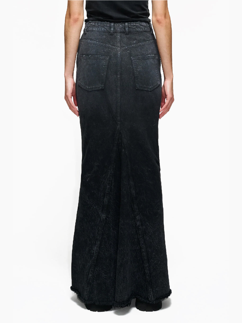 The Annul Skirt Faded Away Grey by Hope is a high-waisted, ankle-length denim skirt in a faded black wash. This long skirt features side pockets, belt loops, and a front zipper with a button closure. The hem is slightly frayed, giving it a distressed look.