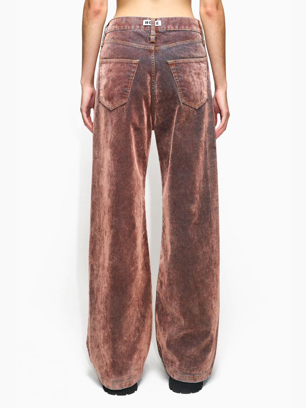 The HOPE Skid Jeans in Rust Flock are vintage-style, wide-legged brown jeans made from Organic Cotton with a faded finish and high waist. They feature classic five-pocket styling and prominent stitching, and are displayed laid flat against a white background.