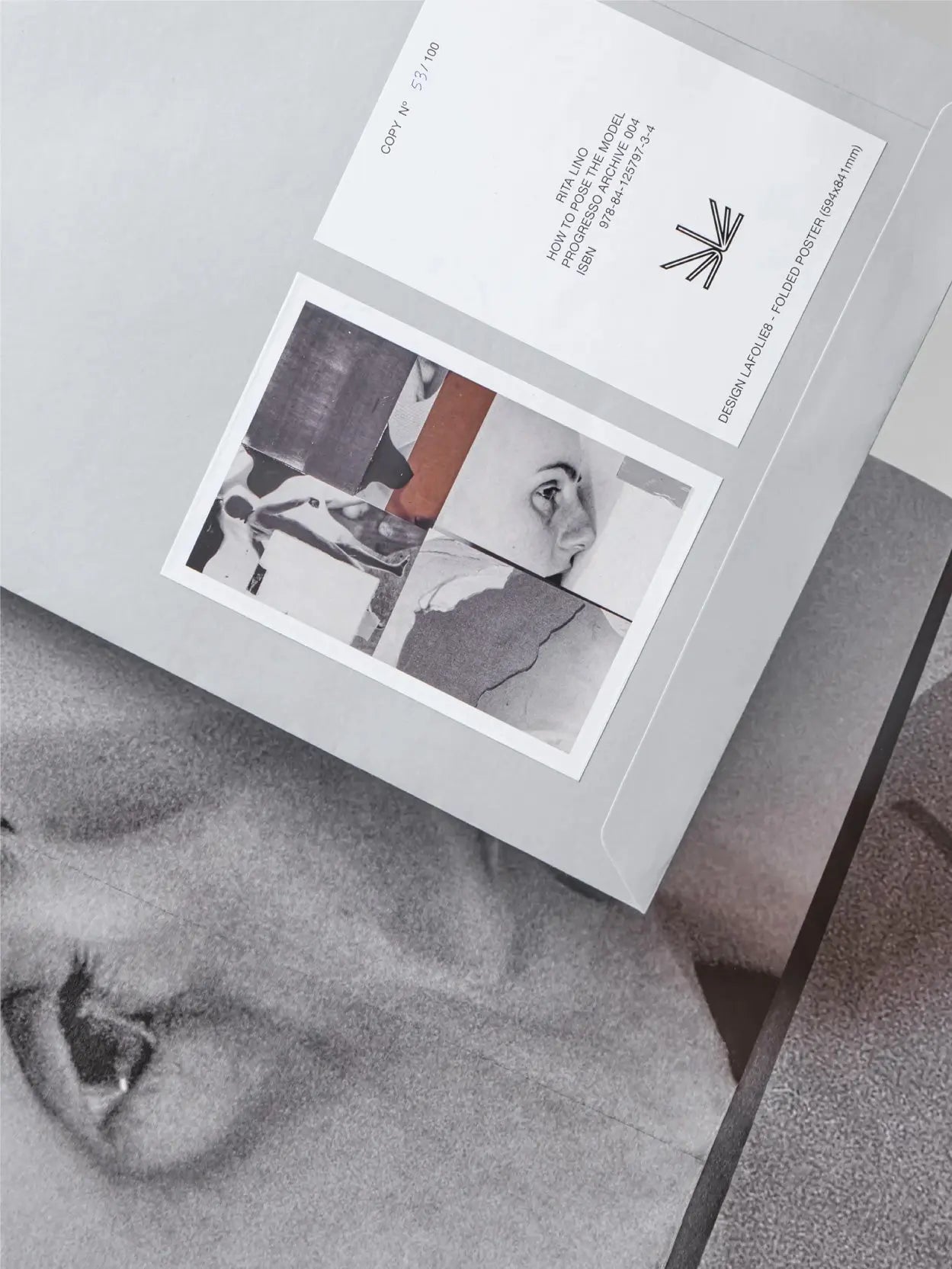 A gray folder on the left side with two black-and-white photos and text on the front. Next to it on the right is a black-and-white photograph featuring an abstract figure of a person in motion. This elegant display might be found in a chic store like Bassalstore in Barcelona, such as "How to Pose the Model by Rita Lino" by Progresso.