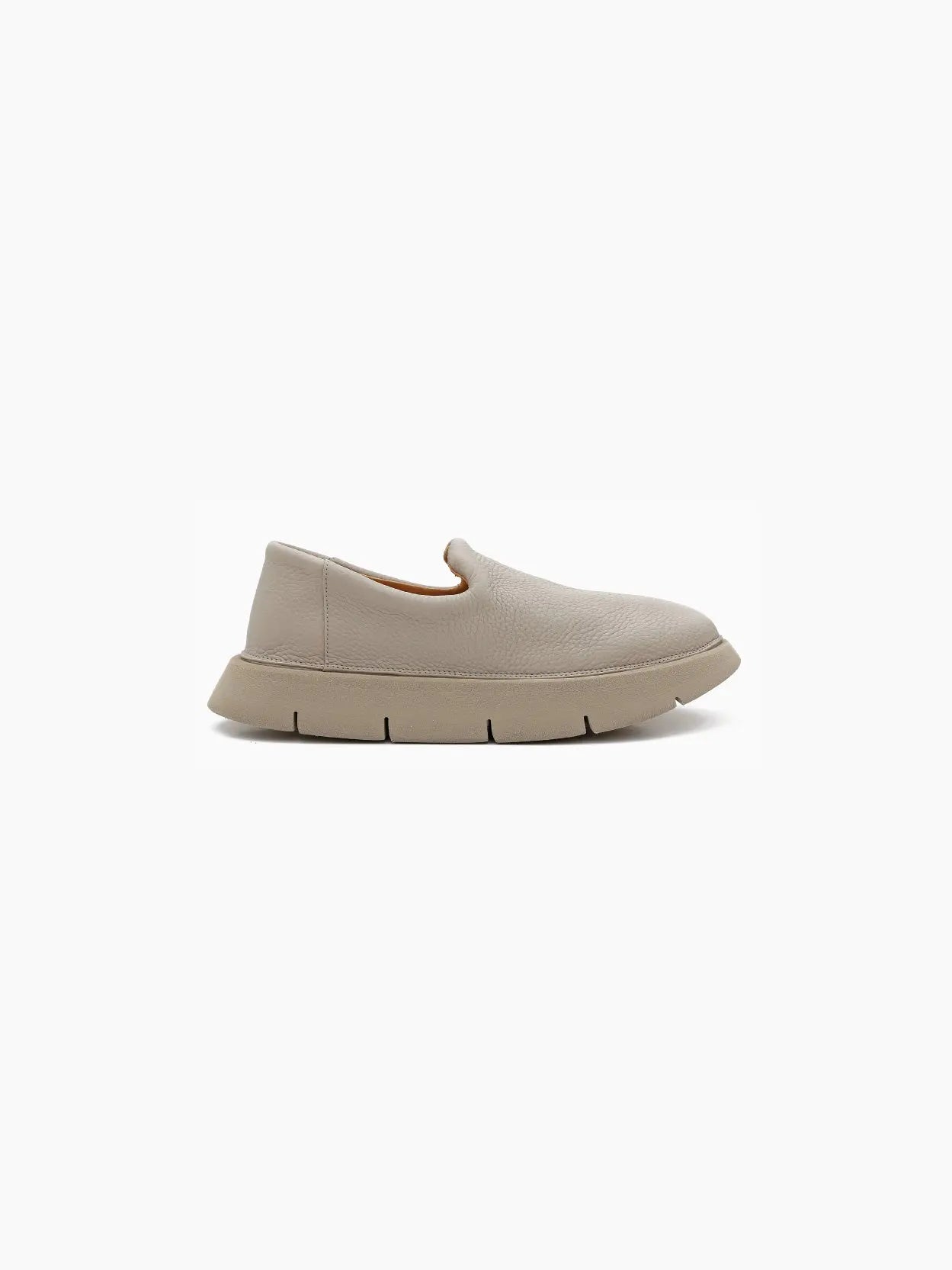 A single beige Intagliata Slip On Clay by Marsèll with a smooth, rounded toe and a slightly flared, chunky sole. The segmented design of the sole ensures flexibility. With its minimalist and modern appearance, this shoe stands out in any setting. Available now at bassalstore in Barcelona. The background is white.