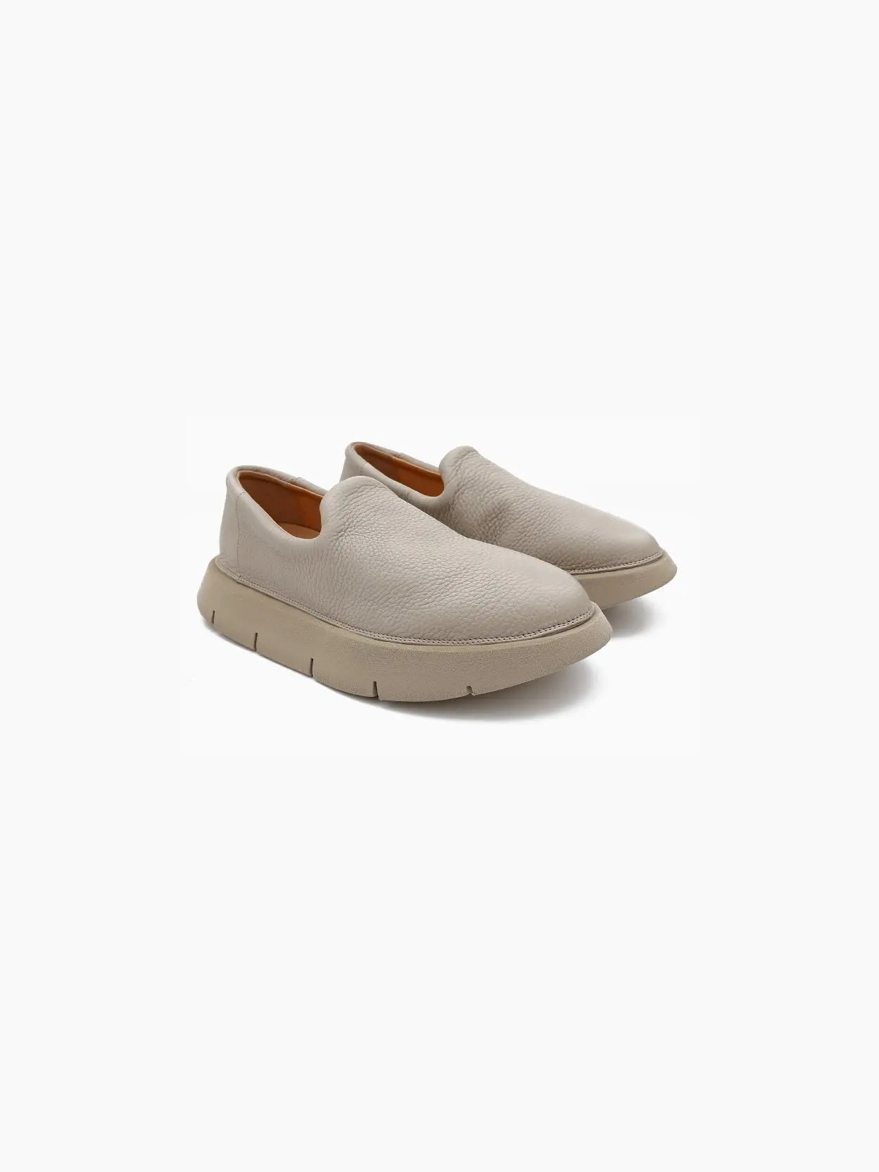 A single beige Intagliata Slip On Clay by Marsèll with a smooth, rounded toe and a slightly flared, chunky sole. The segmented design of the sole ensures flexibility. With its minimalist and modern appearance, this shoe stands out in any setting. Available now at bassalstore in Barcelona. The background is white.