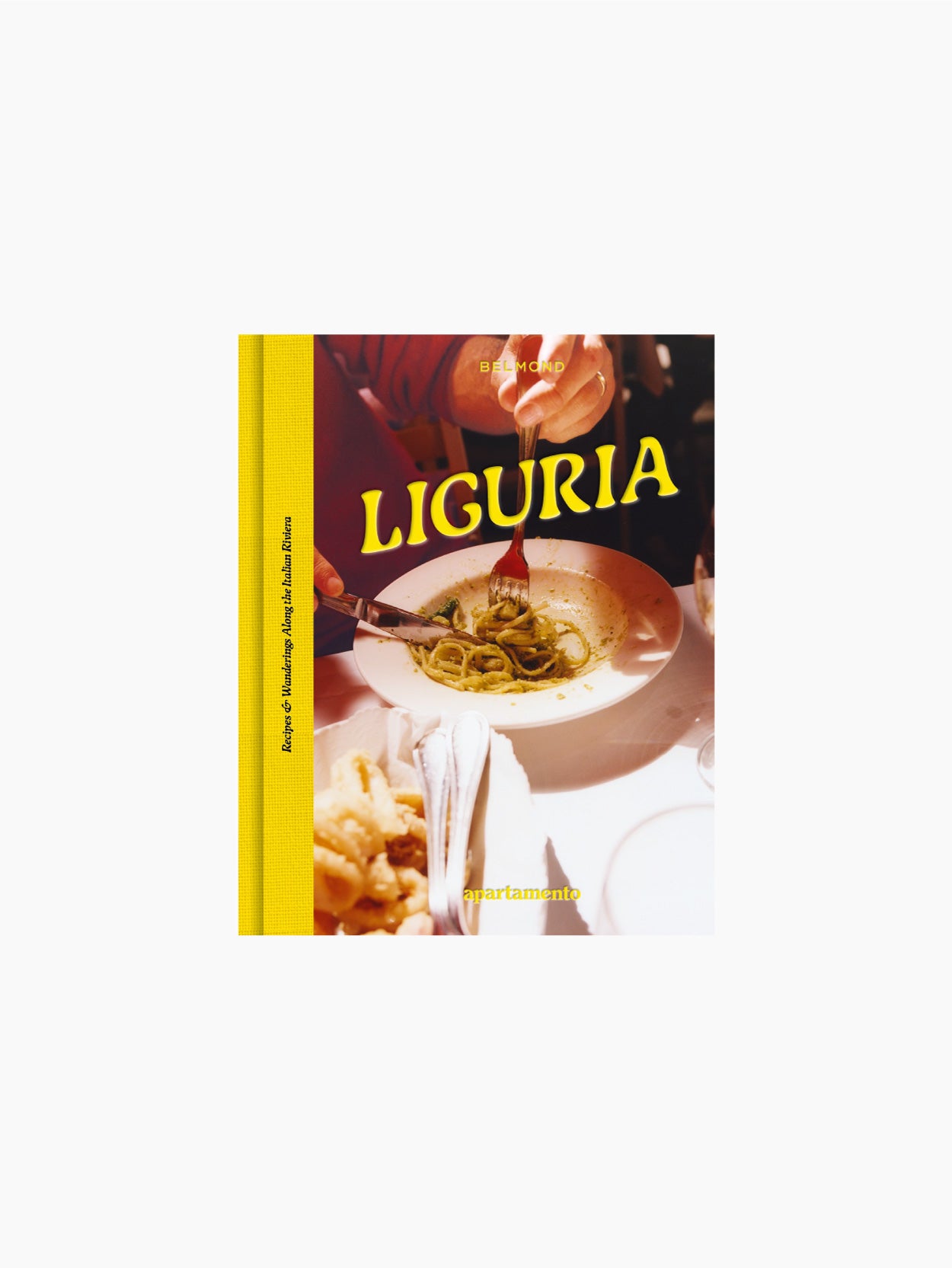 A cookbook titled "LIGURIA: Recipes & Wanderings Along the Italian Riviera," featuring a yellow spine and a cover image of a person enjoying Ligurian cuisine with a plate of pasta with sauce. The background includes a table setting with cutlery and another dish, capturing the essence of the Italian Riviera. "Apartamento" is printed at the bottom of the cover.