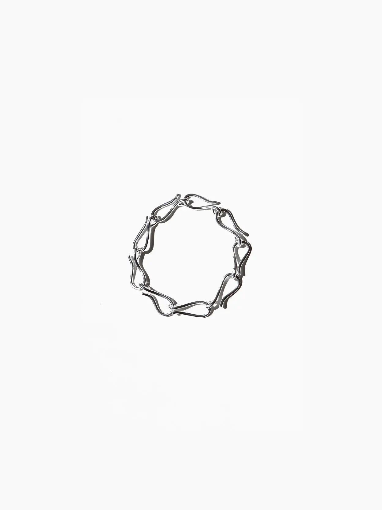 A Lagoa Bracelet by Nathalie Schreckenberg with an abstract, wavy design forming interconnected loops, arranged in a circular shape against a plain white background, available exclusively at Bassalstore in Barcelona.