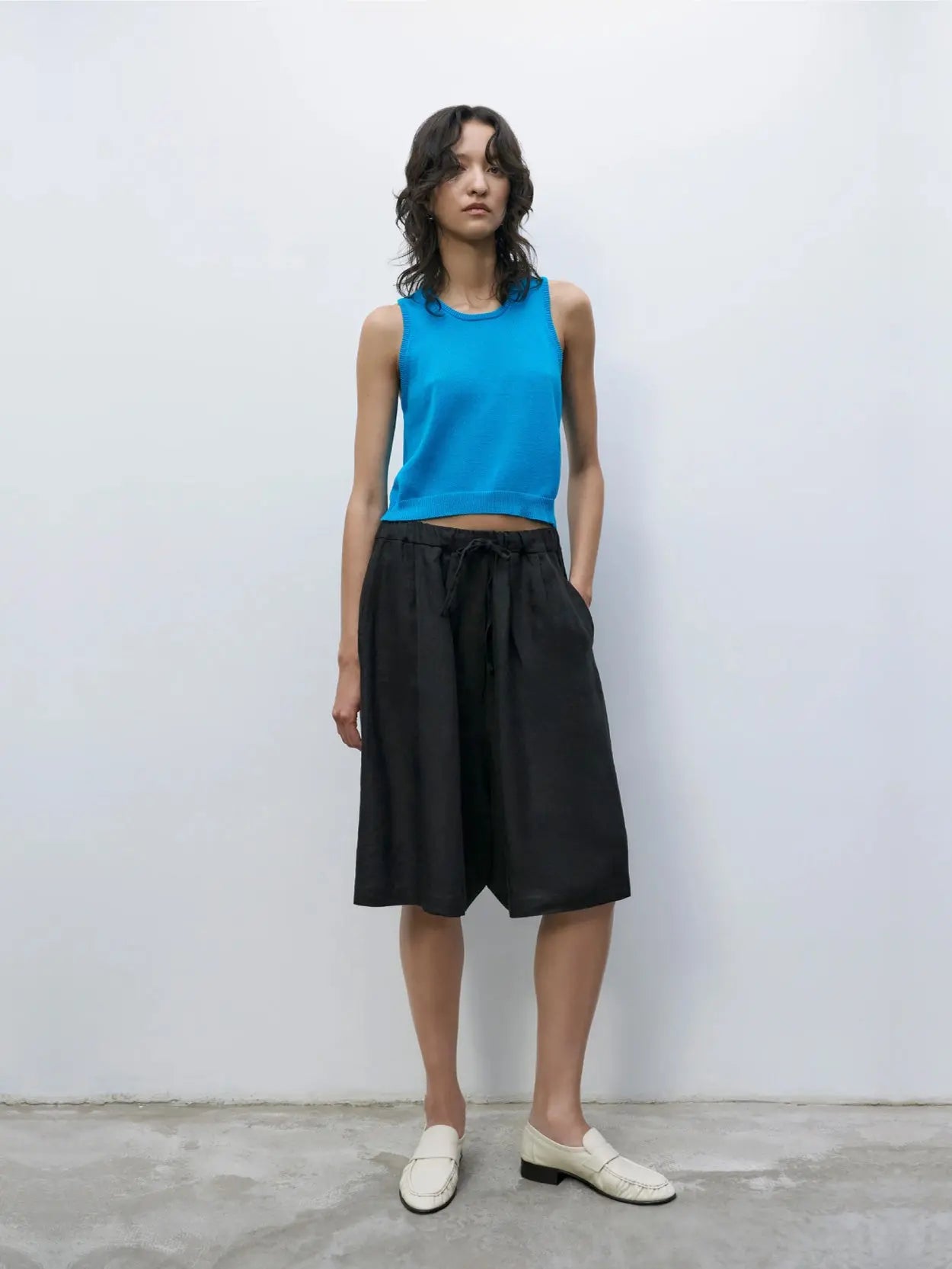 A pair of black, knee-length shorts with an elastic waistband and drawstring, laid flat on a white background. The fabric appears to be lightweight and comfortable, suitable for casual or athletic wear—perfect for browsing through the vibrant streets of Barcelona or grabbing gear from bassalstore. The Linen Maxi Bermuda Black by Cordera would be an excellent choice.