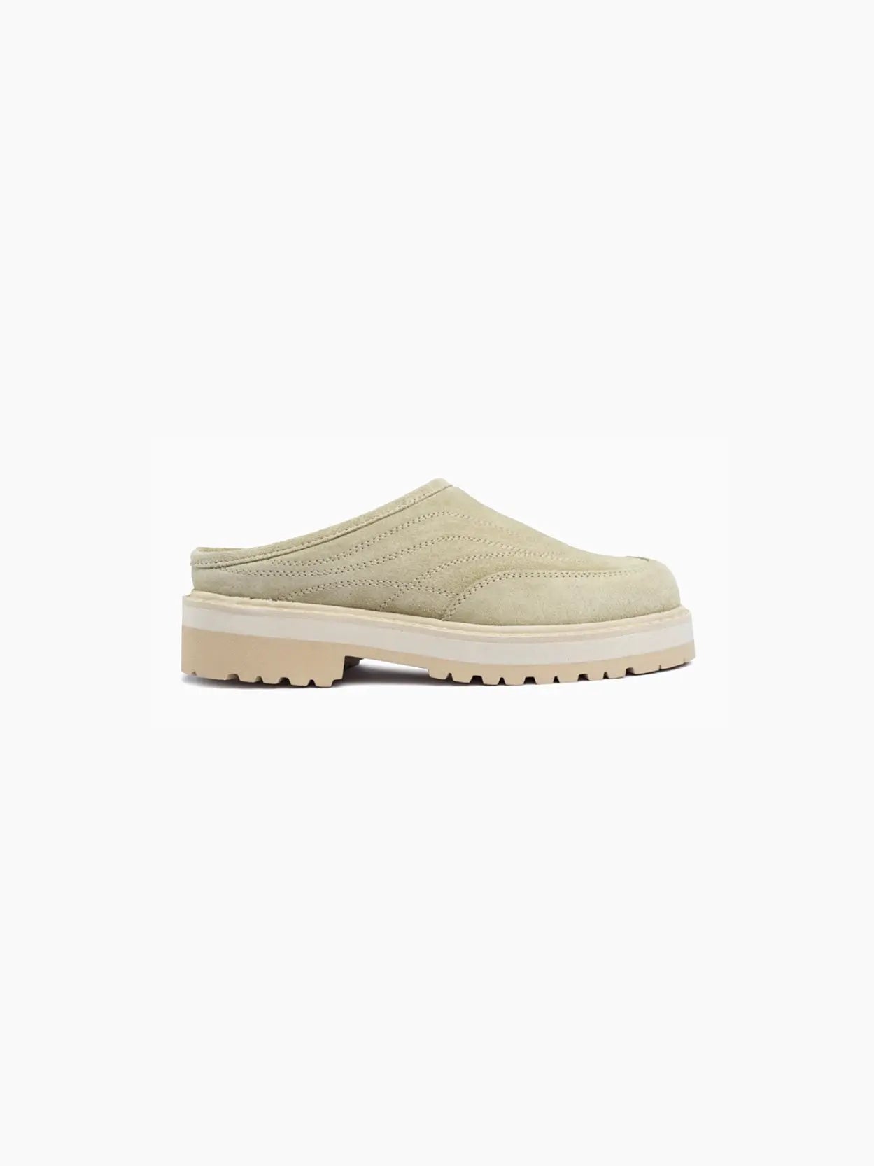 A single beige slip-on shoe, the "Maggiore Ecru Suede" by Diemme, available at bassalstore in Barcelona, featuring a rugged, lugged sole and minimalistic design. The upper part showcases subtle stitched detailing for texture. The shoe has a closed toe and an open back, resembling a mule style. The outsole is slightly thicker, offering added traction.