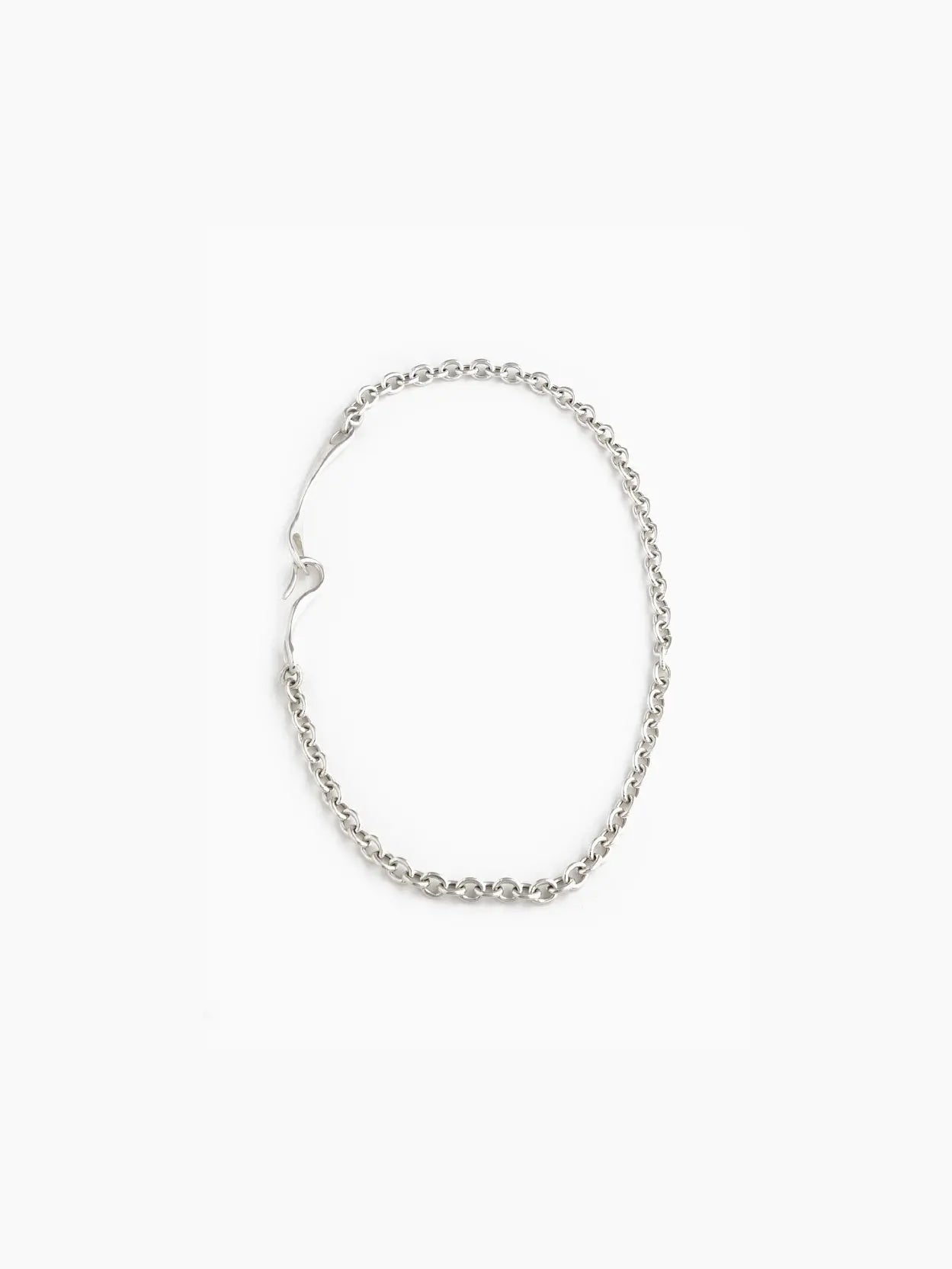 A Maia Necklace from Nathalie Schreckenberg, featuring a linked chain design with a small heart-shaped clasp, laid out in an oval shape on a white background.