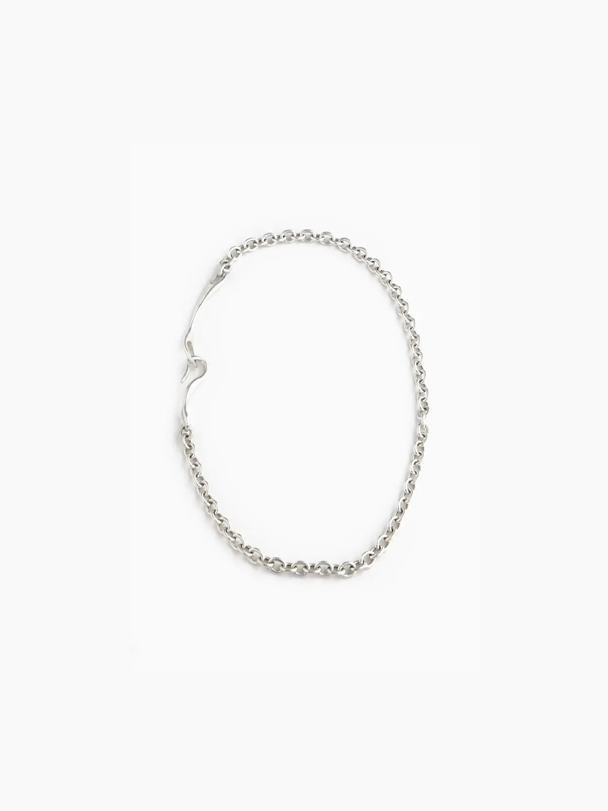A Maia Necklace from Nathalie Schreckenberg, featuring a linked chain design with a small heart-shaped clasp, laid out in an oval shape on a white background.