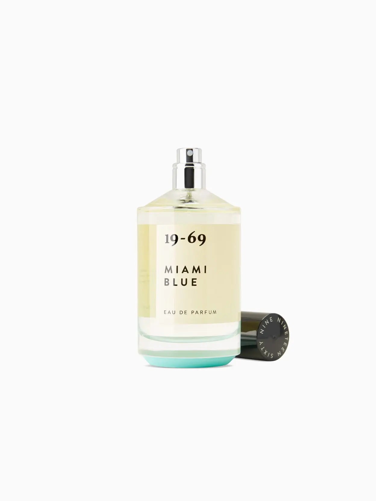 A clear glass bottle of perfume labeled "19-69 Miami Blue 100ml" with black text. The bottle, available at Bassalstore, has a black cap and contains a light yellow liquid. The text below the name reads "EAU DE PARFUM." The background is white.