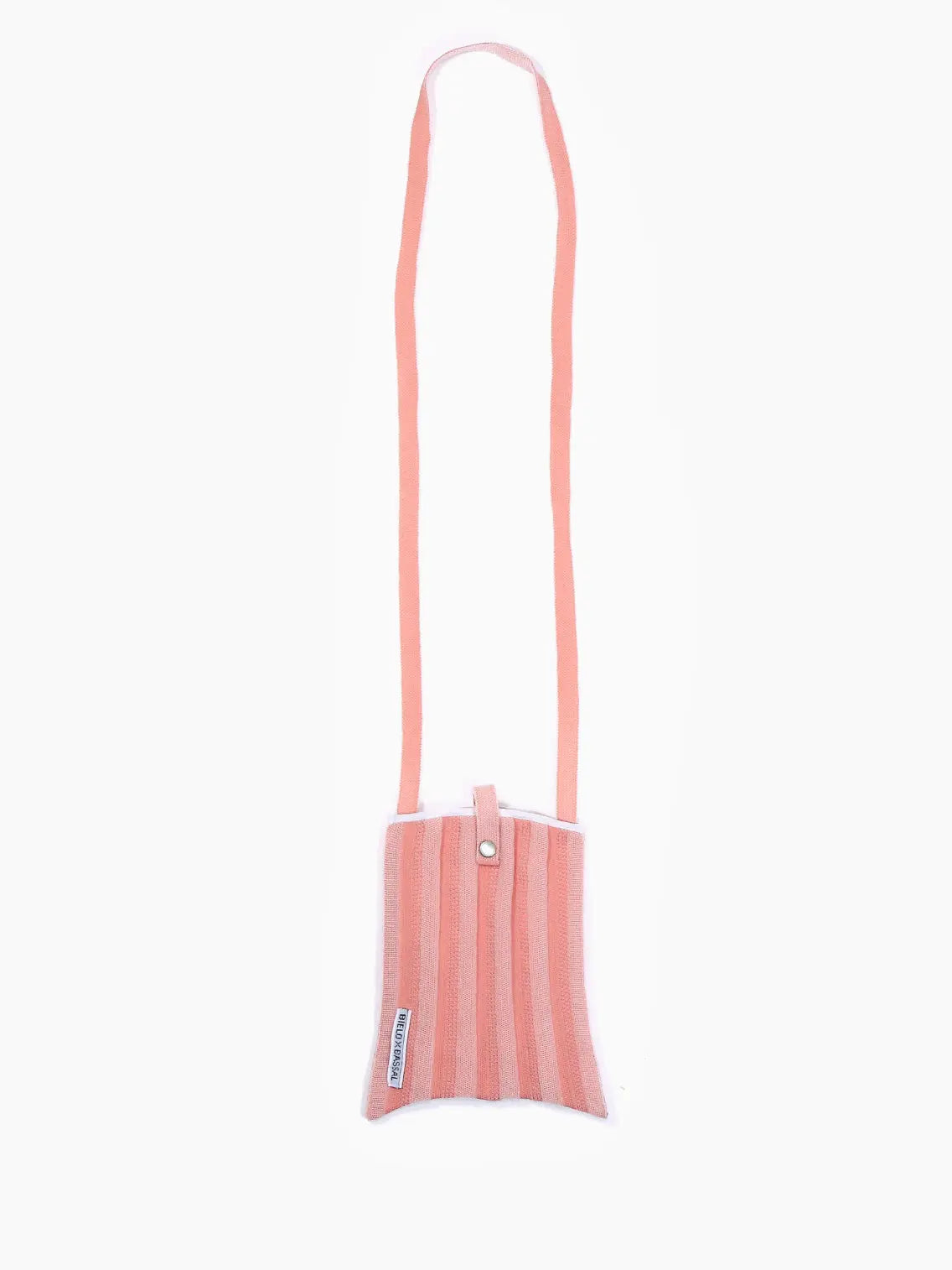 A pink and white striped fabric Pink Shoulder Bag with a top snap closure and a long strap. The Pink Shoulder Bag, available on BassalStore, has a small label on the side that reads "STICK with STYLE." The background is white, making it perfect for your next shopping trip in Barcelona.