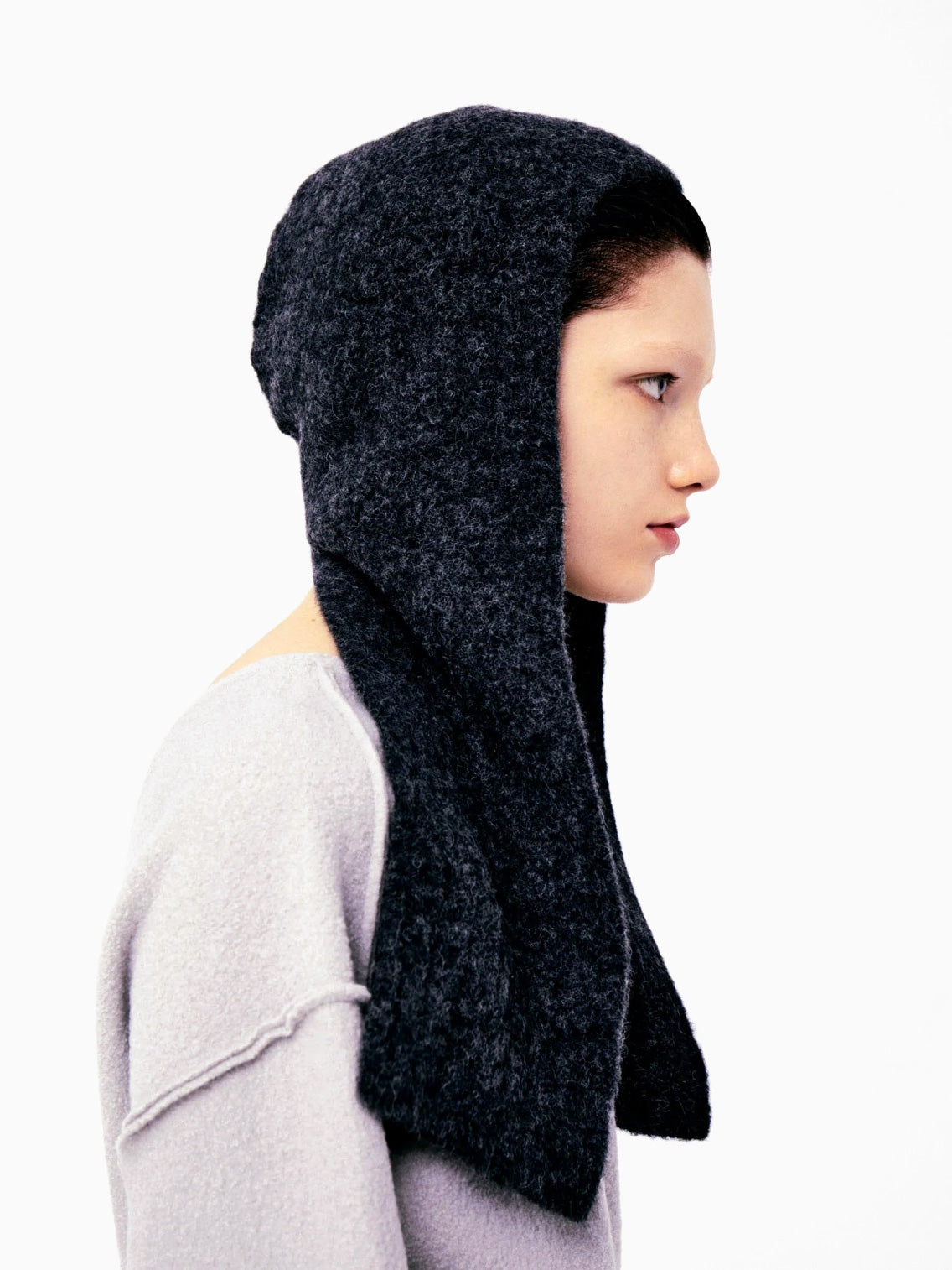 The Mimi Headpiece Graphite by Rus, made from luxurious Italian yarn, showcases a simple, textured knit design in gray and is displayed on a plain white background.