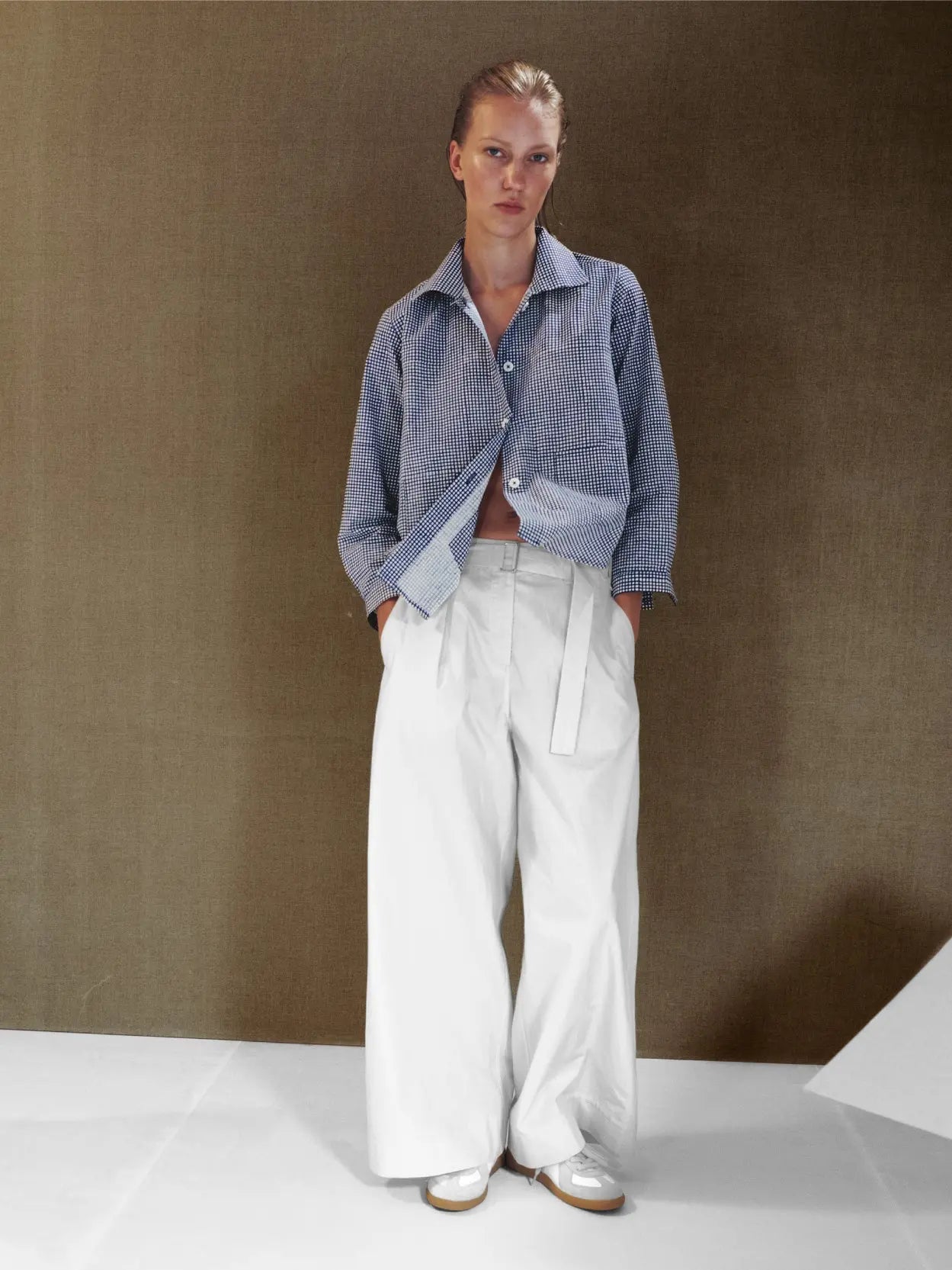 A pair of Rachel Pants Natural by Jan Machenhauer with a fabric belt at the waist, shown against a plain white background. Available exclusively at Bassalstore in Barcelona, the pants feature a minimalist design with subtle pleats and clean lines.