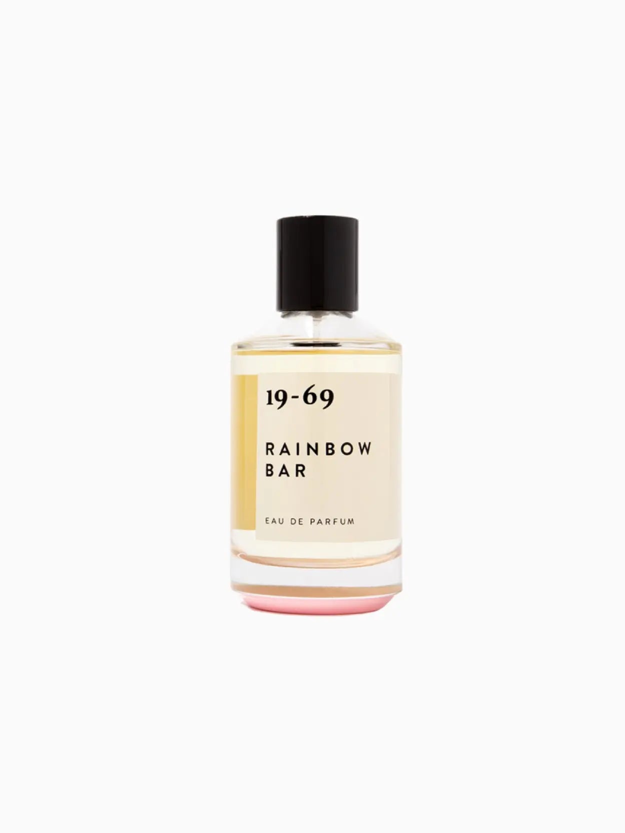 A bottle of perfume labeled "Rainbow Bar 100ml" by 19-69 stands elegantly. The transparent bottle with a black cap reveals a light yellow liquid inside. Its minimalist label, featuring black text on a white background, hints at the sophistication you'd find in a boutique store in Barcelona.