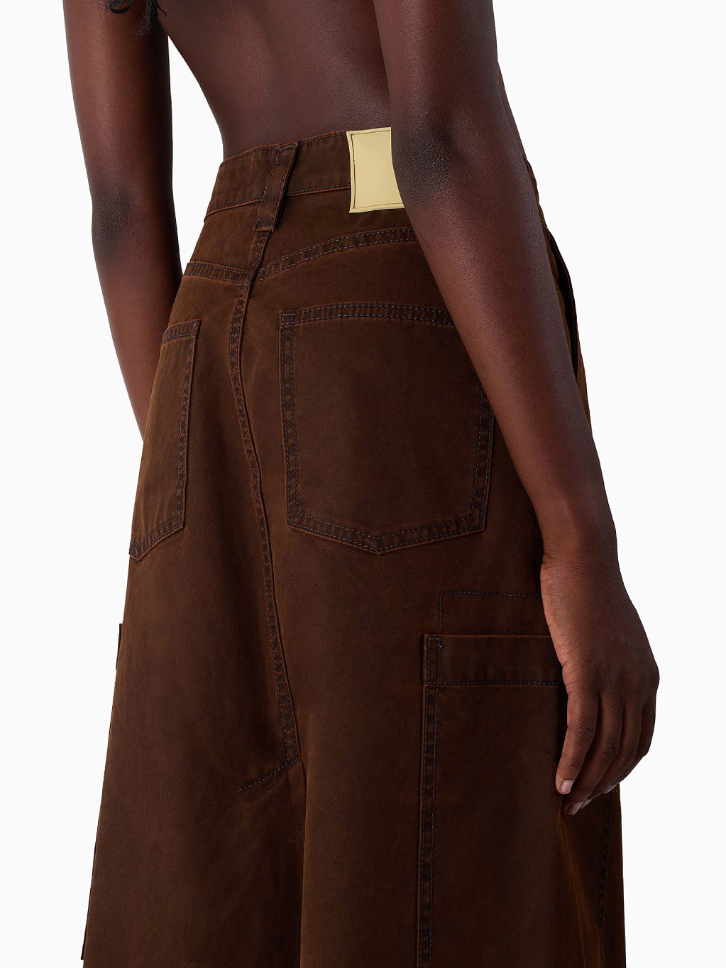 The Cargo Skirt Brown by Sunnei is an A-line midi skirt crafted from 100% cotton, featuring a high waist, two large front pockets, and a front button closure. Its sturdy fabric makes it perfect for everyday wear.