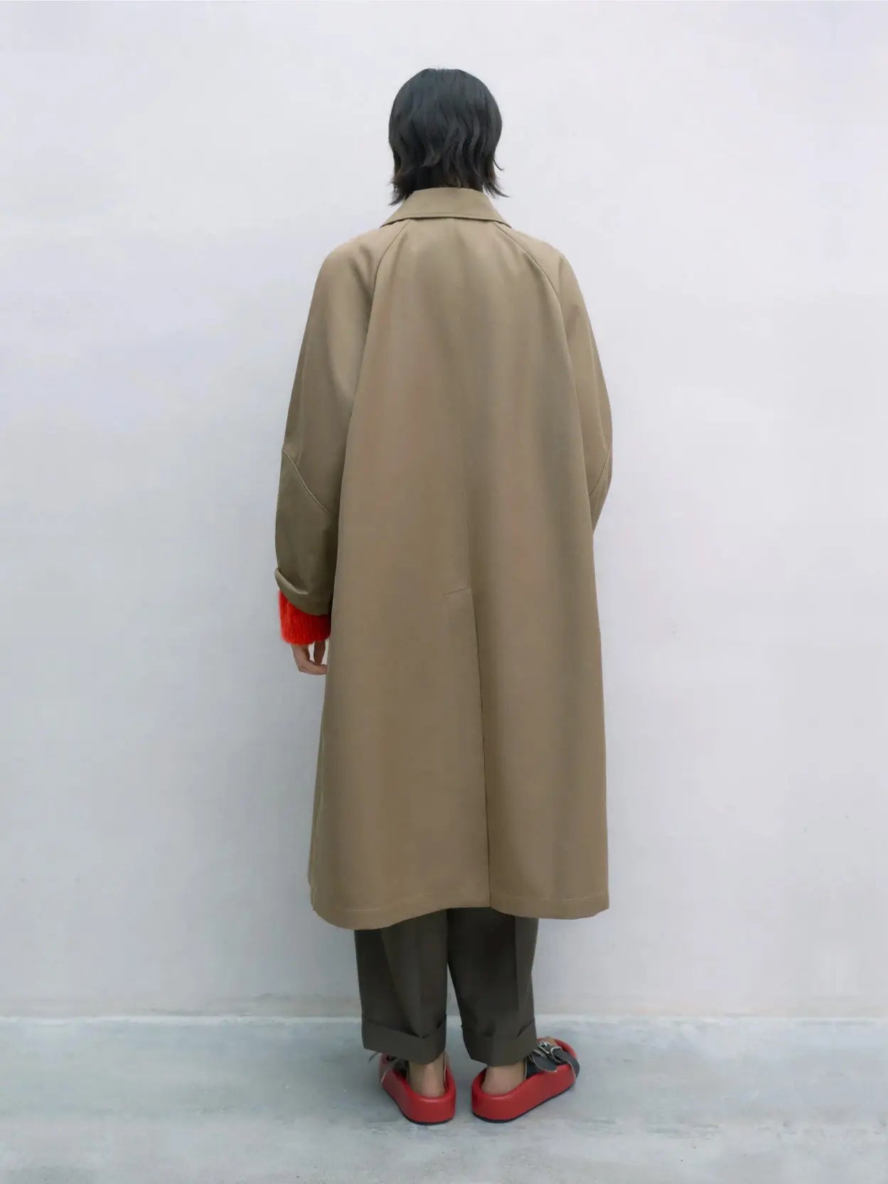A long beige Trench Coat Camel with a collared neckline, designed for a straight fit. It features long sleeves, two front flap pockets, and a concealed front button closure. Available at Bassalstore in Barcelona, the label tag at the neckline reads "Cordera.