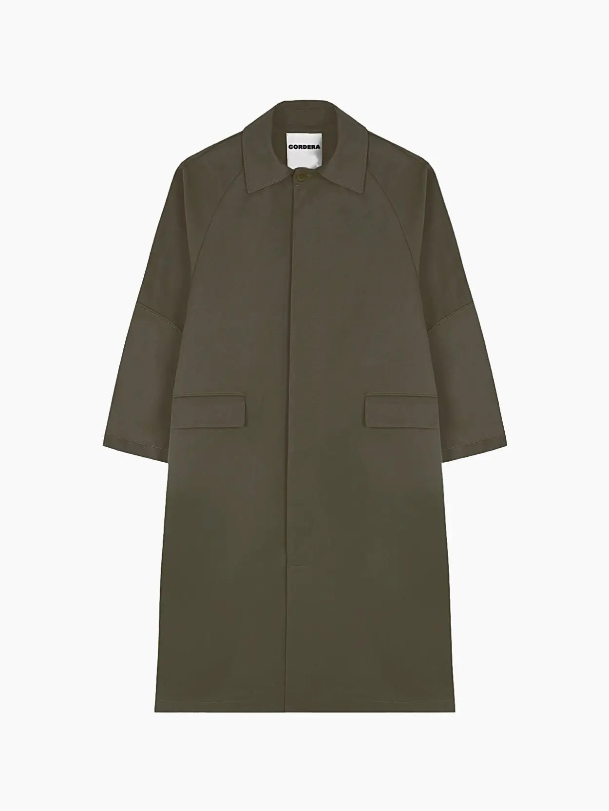A knee-length, dark green trench coat featuring large front pockets, long sleeves, and a pointed collar. The minimalist design includes a concealed button closure and a plain back, creating a sleek and timeless look. Available at the Barcelona-based store "Bassalstore," the label "Cordera" is visible inside the collar.