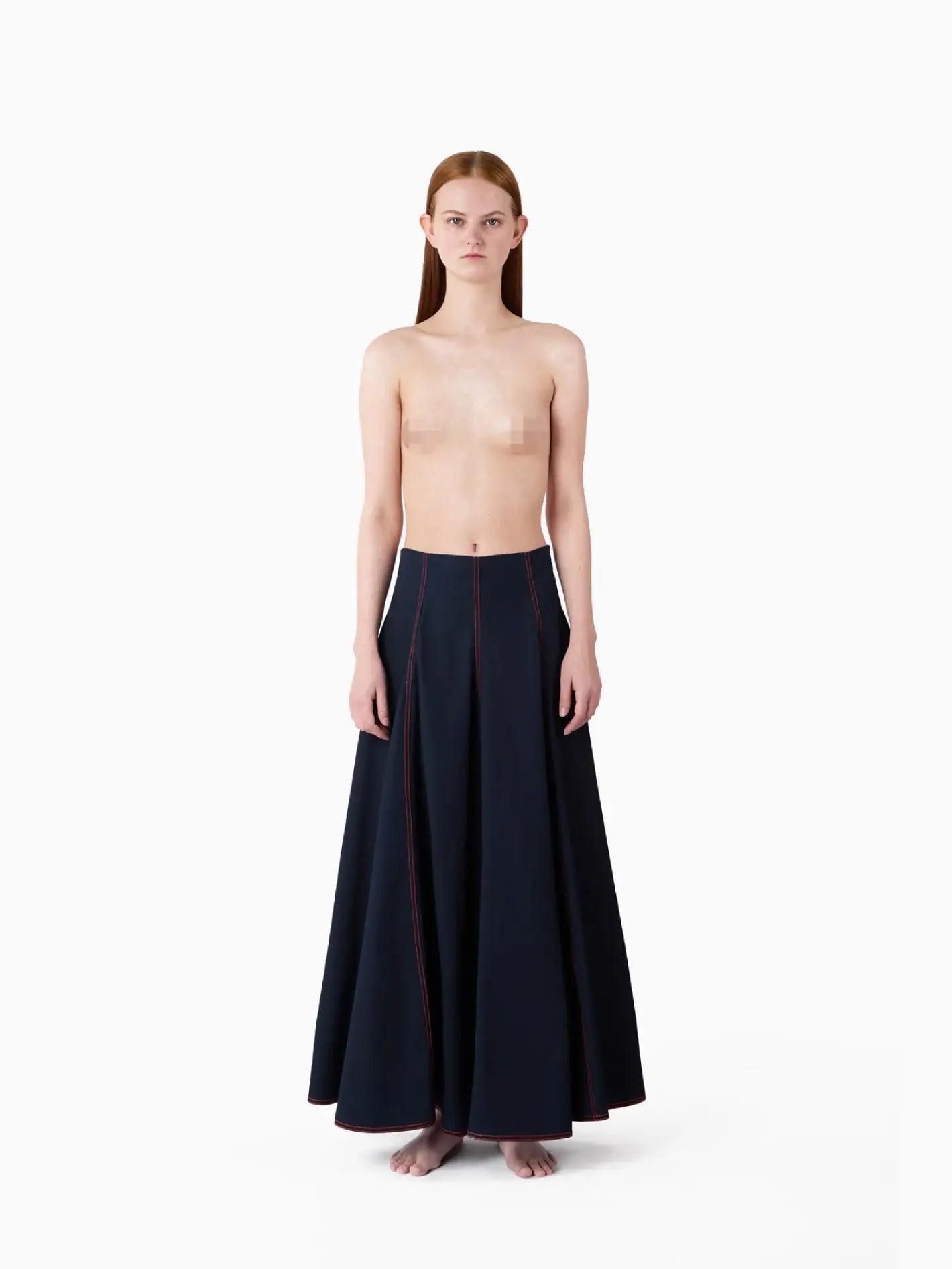 A navy blue Tulipano Skirt Washed Denim with red stitching accents on vertical seams from Sunnei. The skirt flares out slightly with pleats, offering a classic and elegant design. The background is plain white, highlighting the skirt’s details.