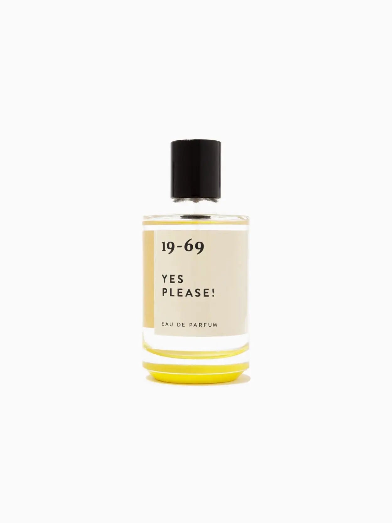 A bottle of Yes Please! 100ml eau de parfum by 19-69 with a black cap and the label "19-69 YES PLEASE!" written on the front. The liquid inside the clear bottle is yellow, perfectly staged against a pristine white background, available now at Bassalstore in Barcelona.