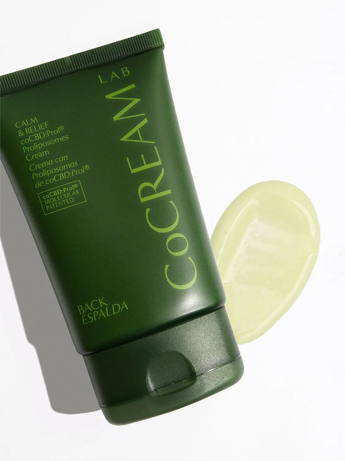 A green squeeze tube labeled "CoCream Lab" containing Back Cream 100ml is sold at Bassalstore in Barcelona. The text on the tube includes information in Spanish, mentioning features like "Calm & Relief" and "Crema con Polipéptidos." The packaging design is simple and minimalistic.