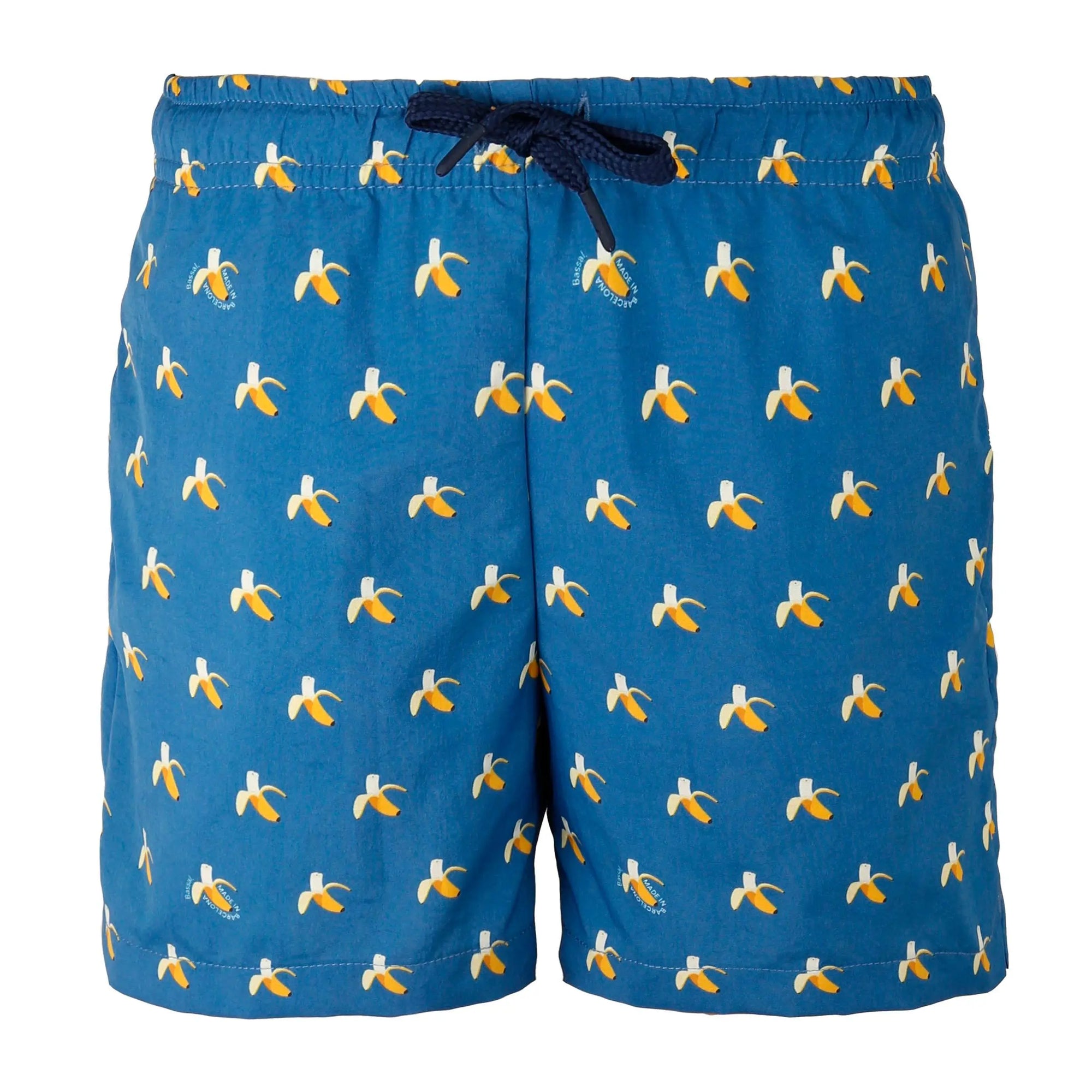 A pair of blue Bananas Kids Swimwear with a yellow and white banana print is neatly displayed in an orange-lined gift box. The swimwear has a navy blue drawstring and is tagged with a Bassal. kids label. The box lid features the brand name "Bassal" from bassalstore, your go-to store for fun fashion.
