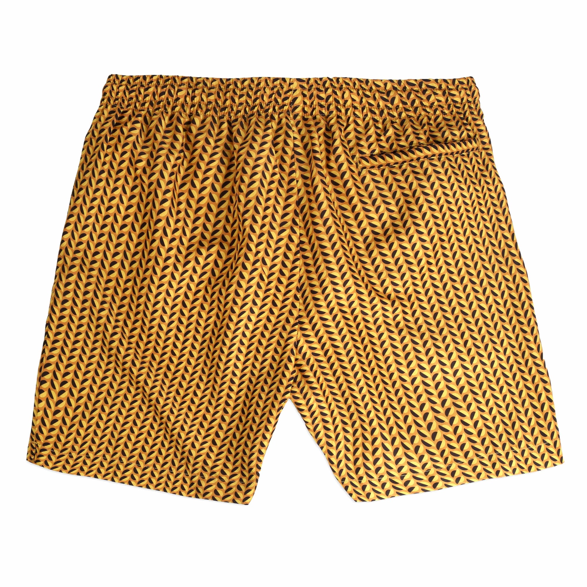 A pair of Clams yellow Swimwear featuring yellow and black leaf-like designs is neatly placed inside an open white box. The box lid, positioned on the left, showcases the brand name "Bassal." An orange cord is also visible, along with a tag featuring the brand name and "bassalstore" from Barcelona.