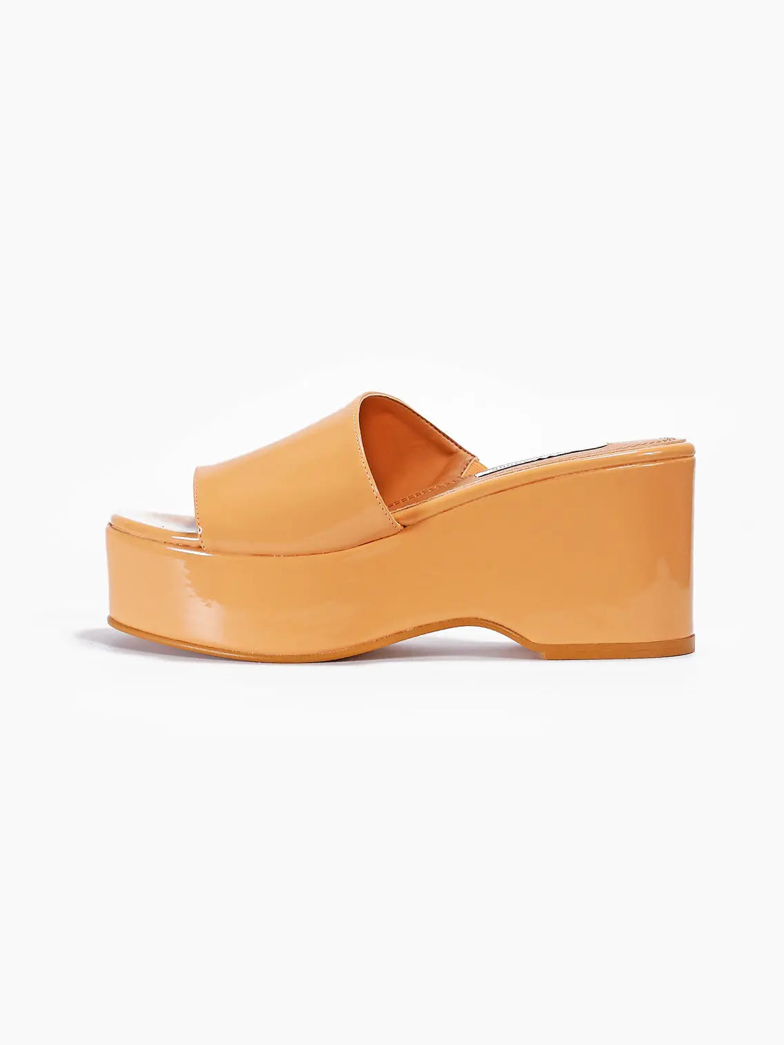 A single Giuliana Peach Sandal with a glossy finish is displayed against a white background. The sandal, available at Bassalstore in Barcelona, features a thick sole and an open-toe design, with a wide strap across the top of the foot and a convenient slip-on style. The brand name is About Arianne.